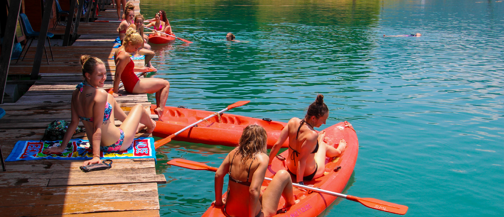 Travelers enjoy kayaking and swimming from floating bungalows in Khao Sok National Park, Thailand.