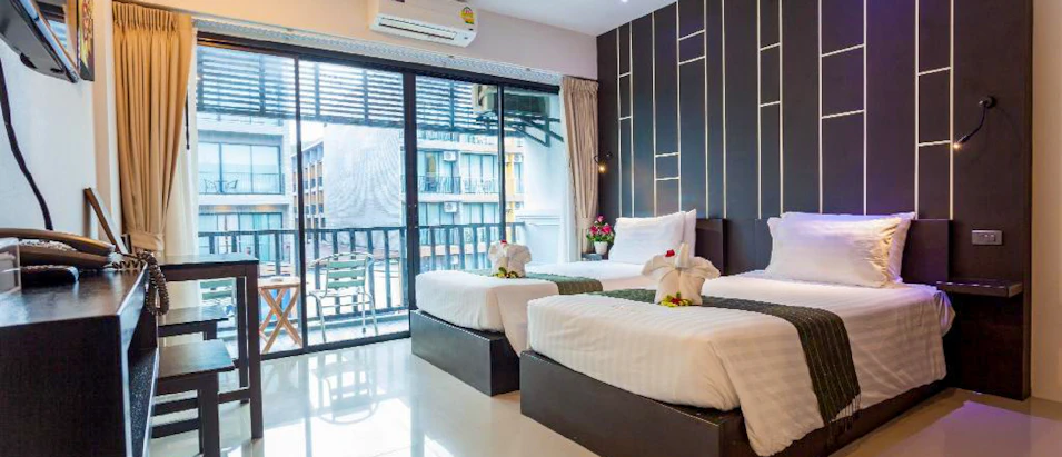 A bright, modern hotel room in Thailand with two single beds, a balcony, and stylish decor.