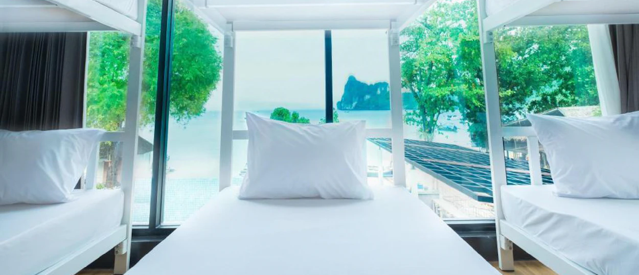 Clean bunk beds in a bright room overlooking the stunning tropical bay of Koh Phi Phi.
