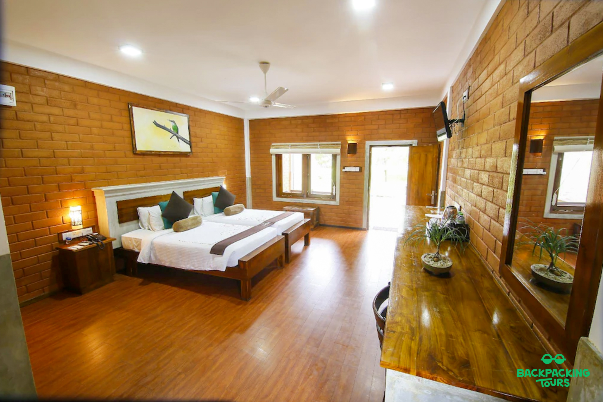 Spacious and inviting hotel room in Dambulla, Sri Lanka, with two beds and brick walls.