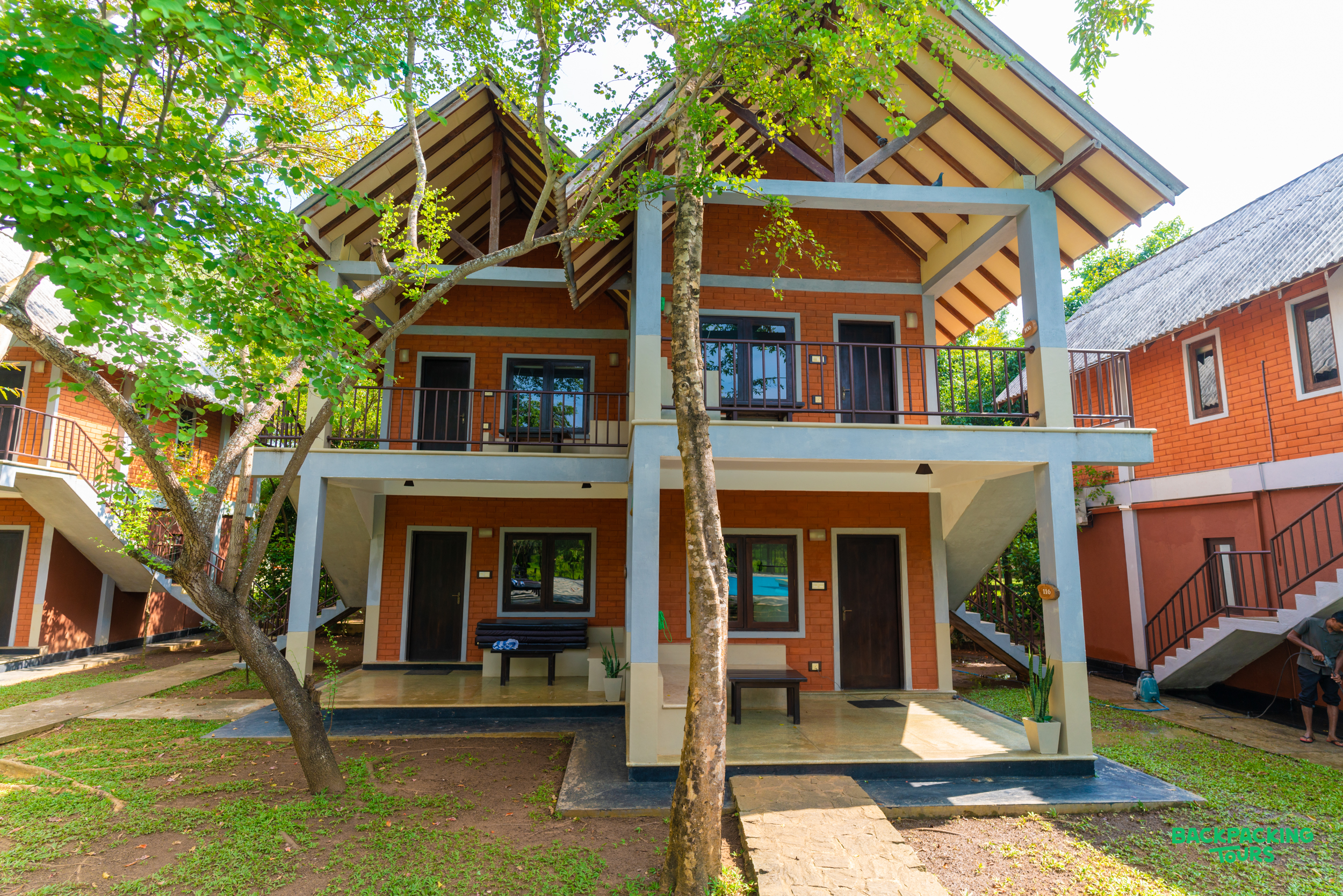 Inviting two-story accommodation with balconies and a lush green garden in Dambulla, Sri Lanka.