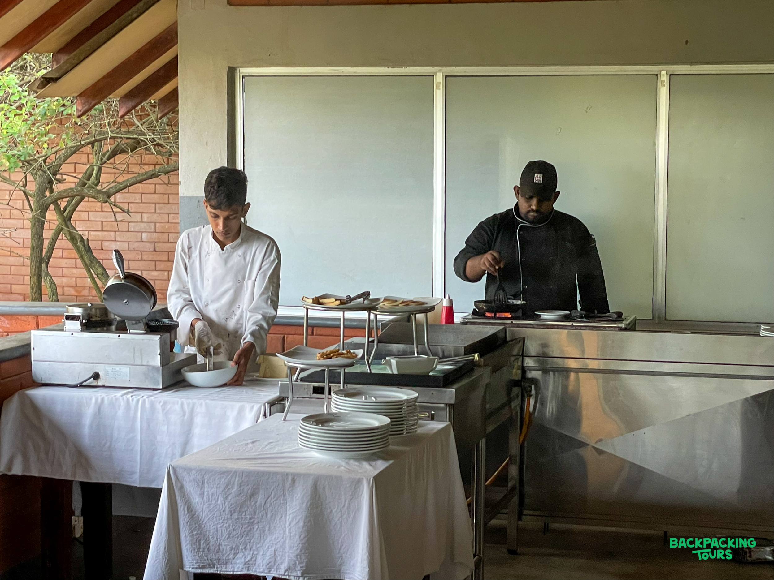 Hotel staff prepare fresh breakfast items at an outdoor buffet station in Dambulla, Sri Lanka.