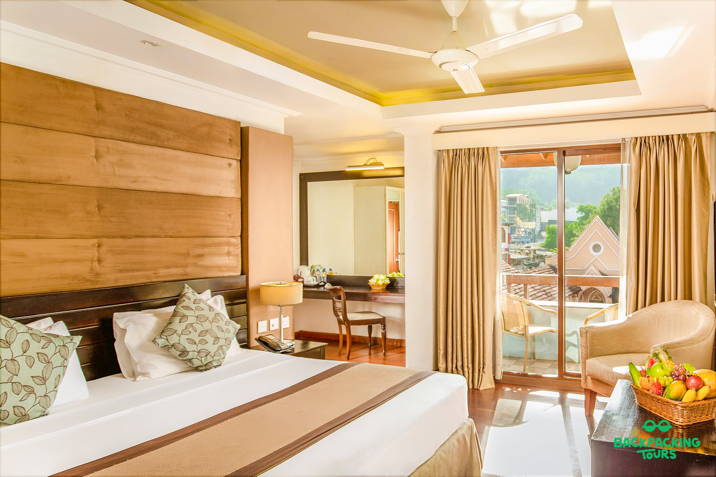 Spacious hotel room in Sigiriya with a large bed and a balcony offering a town view.