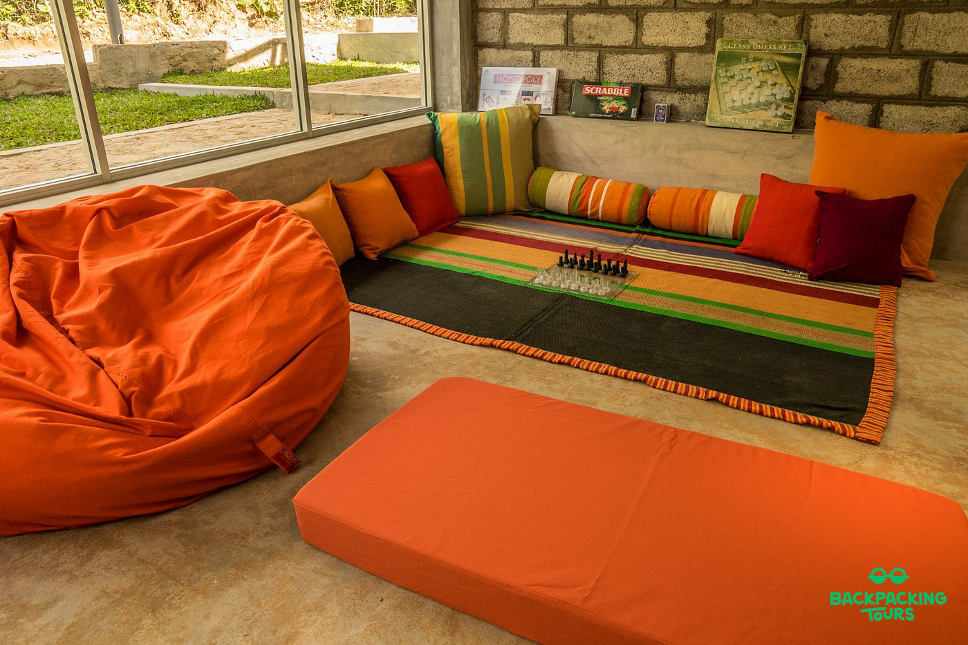 A welcoming common area in Ella with an orange bean bag, floor cushions, and a board game.