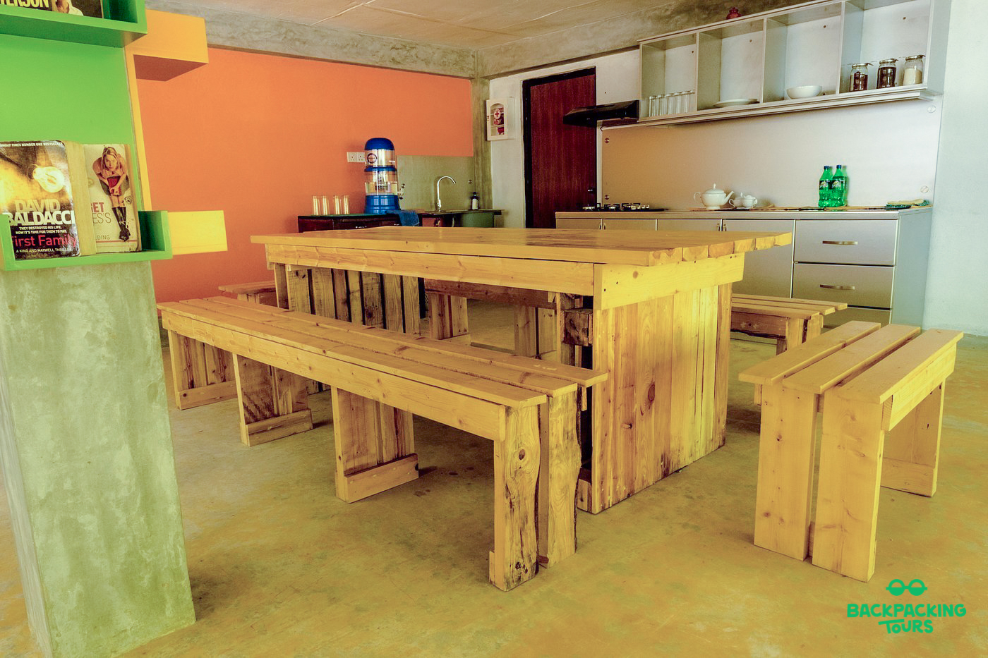 A bright and functional common area with a long wooden dining table and benches in Ella, Sri Lanka.