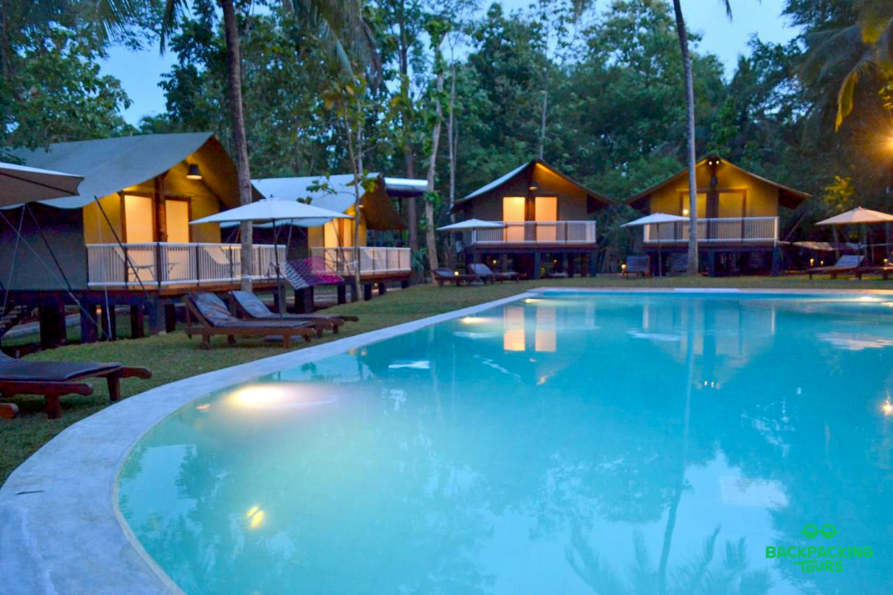 Relaxing evening at a tropical resort in Weligama, Sri Lanka, with bungalows and an inviting swimming pool.