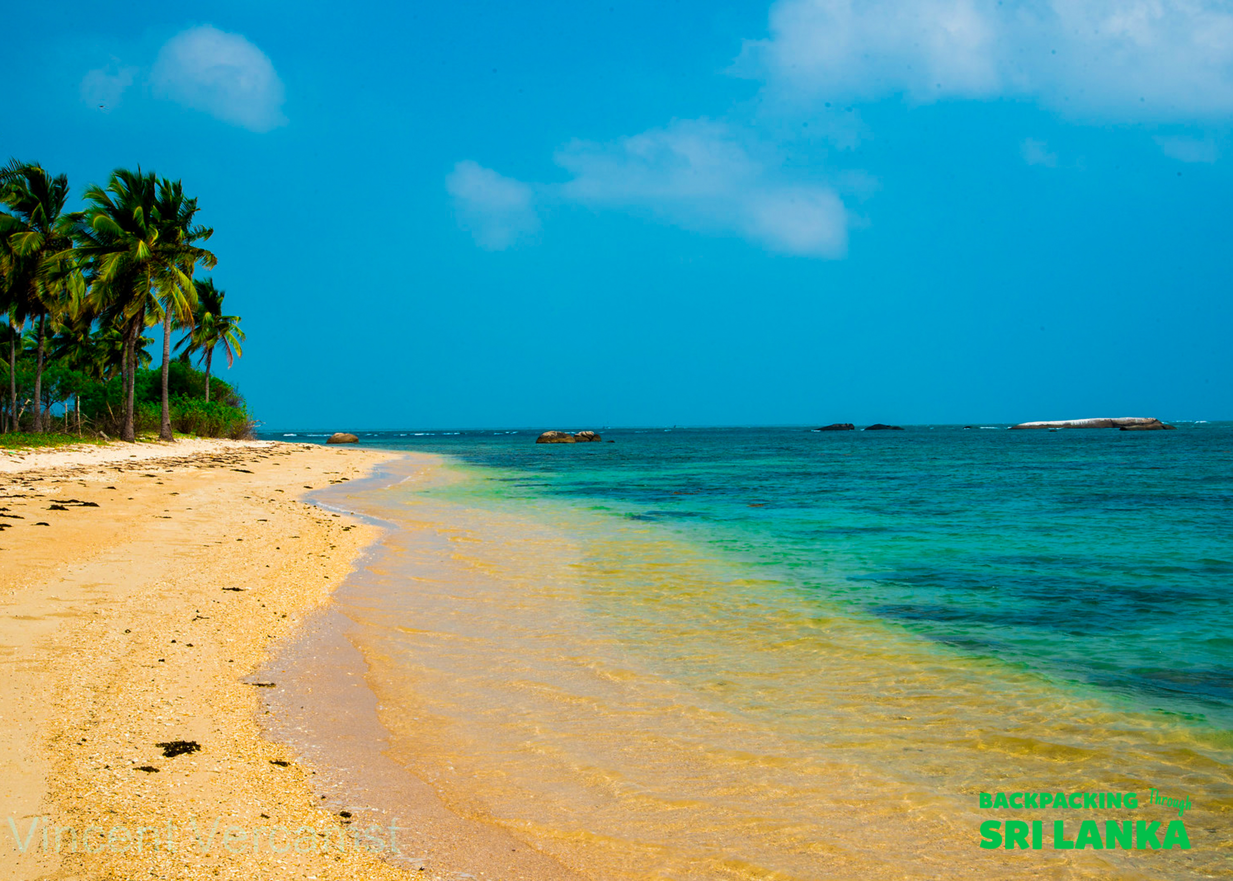 Golden sand and clear turquoise water on a beautiful tropical beach in Unawatuna, Sri Lanka.