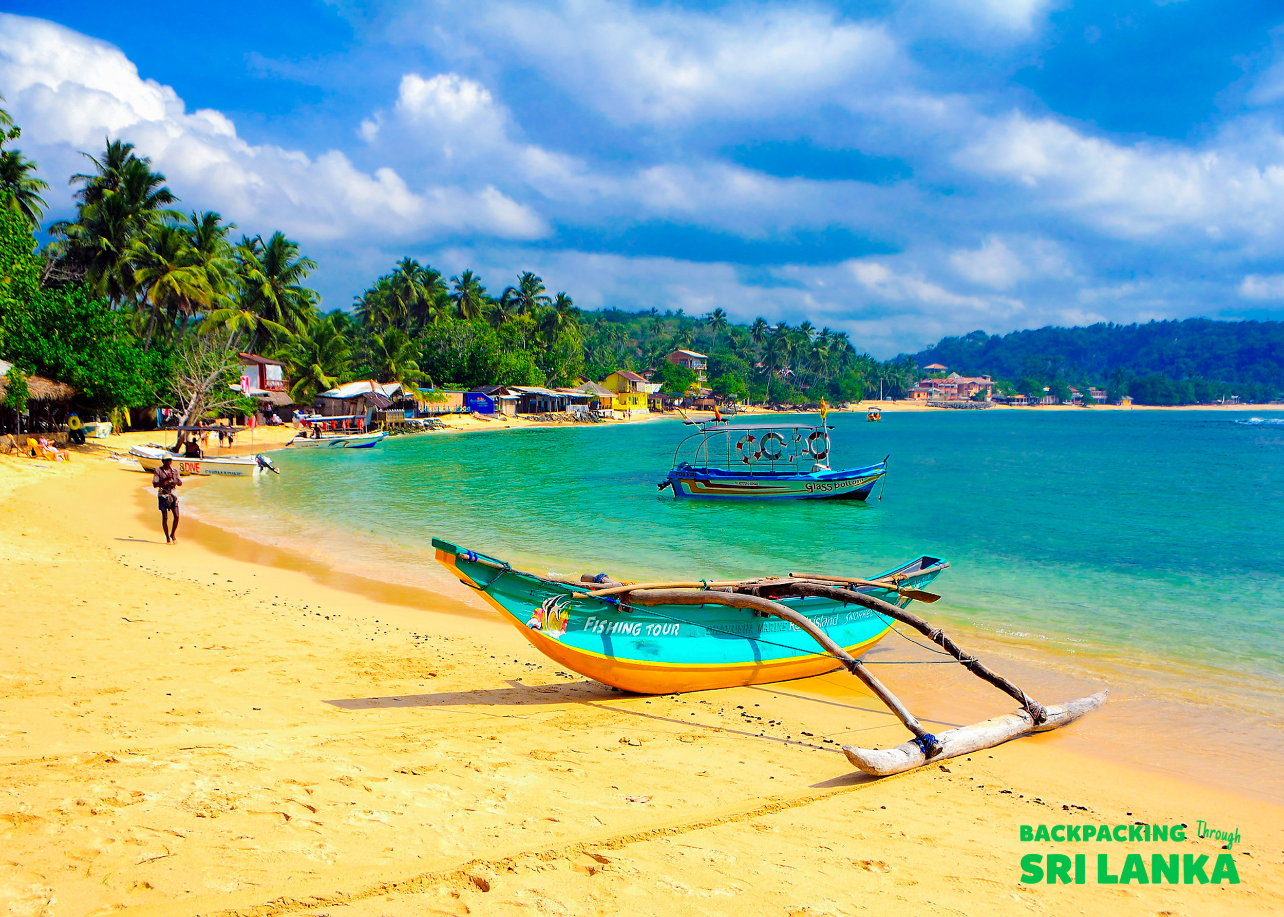 A vibrant tropical beach in Unawatuna, Sri Lanka, with a colorful boat on the sand and clear blue water.