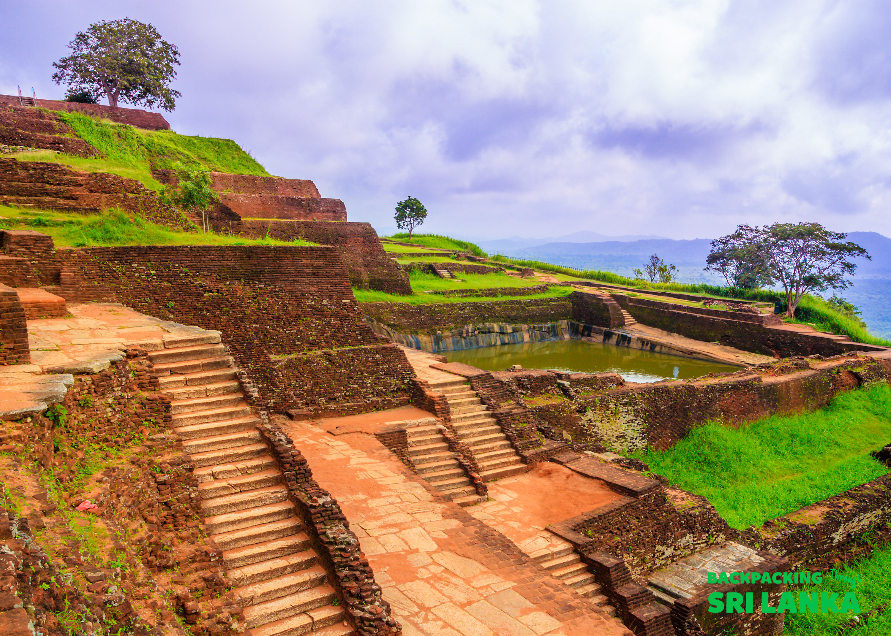 Ancient brick ruins of Sigiriya Rock fortress, with terraces, steps, and a serene water garden.