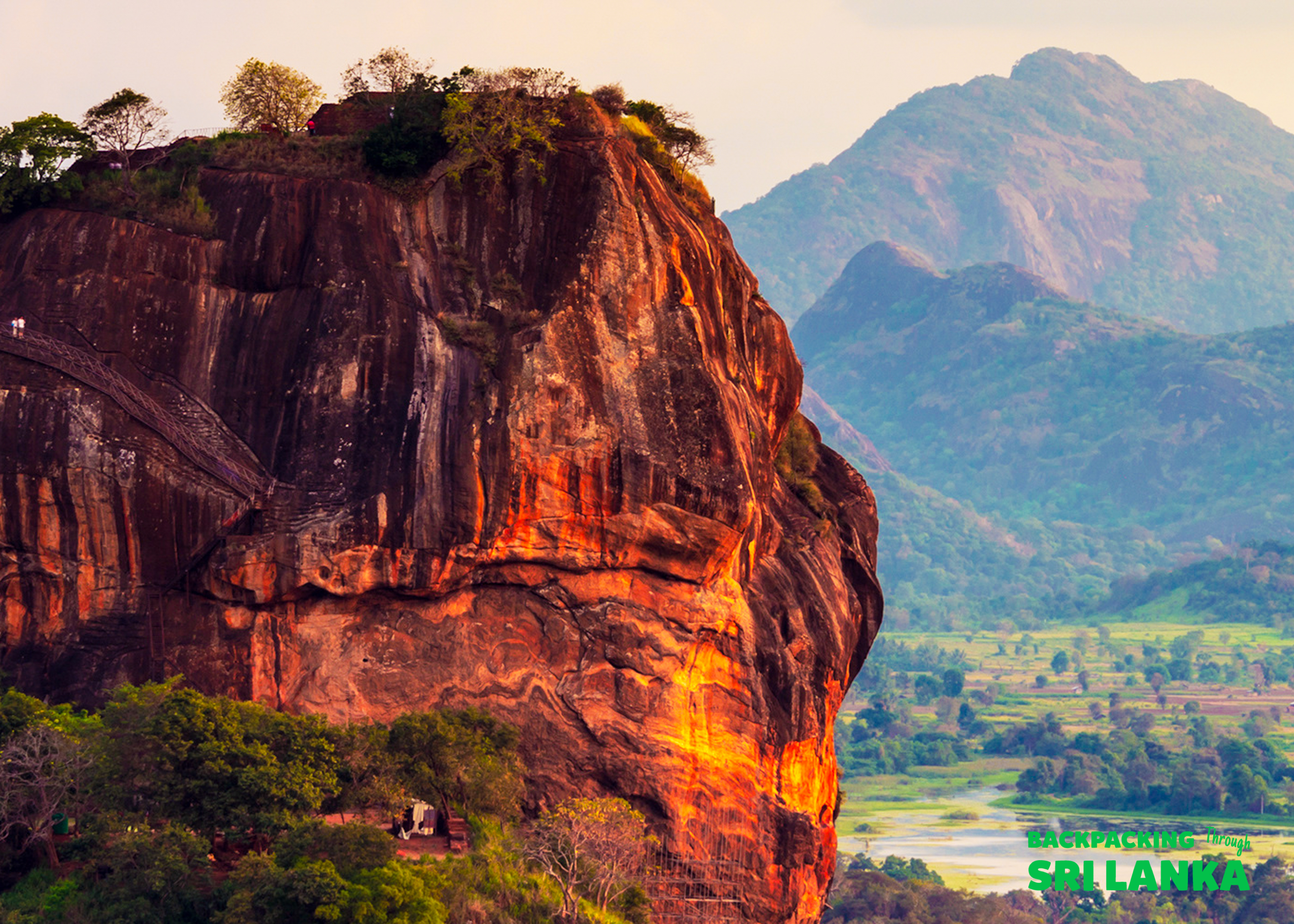 Sigiriya Rock, Sri Lanka, glows in warm light, showcasing its ancient fortress and winding ascent.