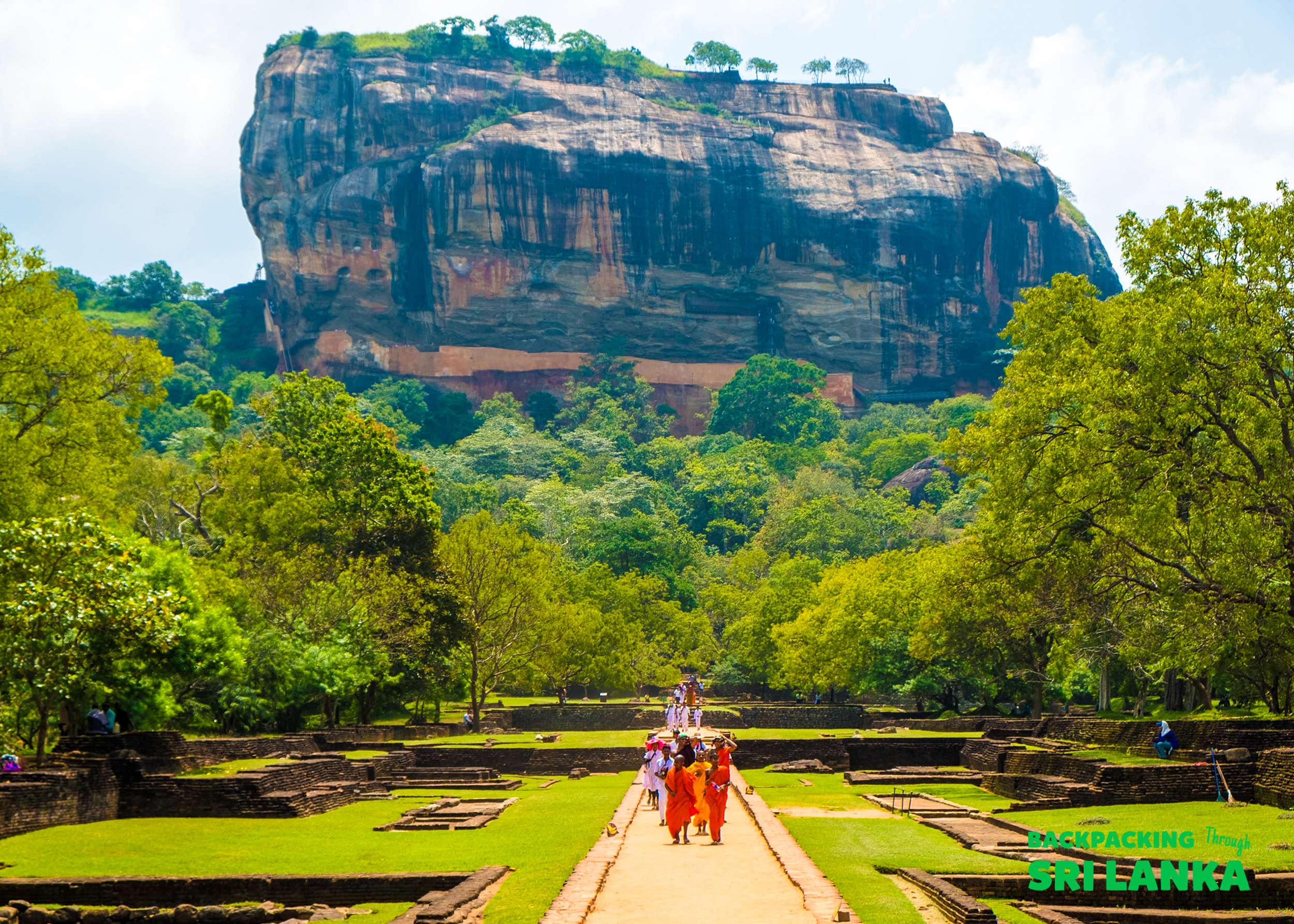 Visitors walk through ancient gardens towards the magnificent Sigiriya Rock in Sri Lanka.