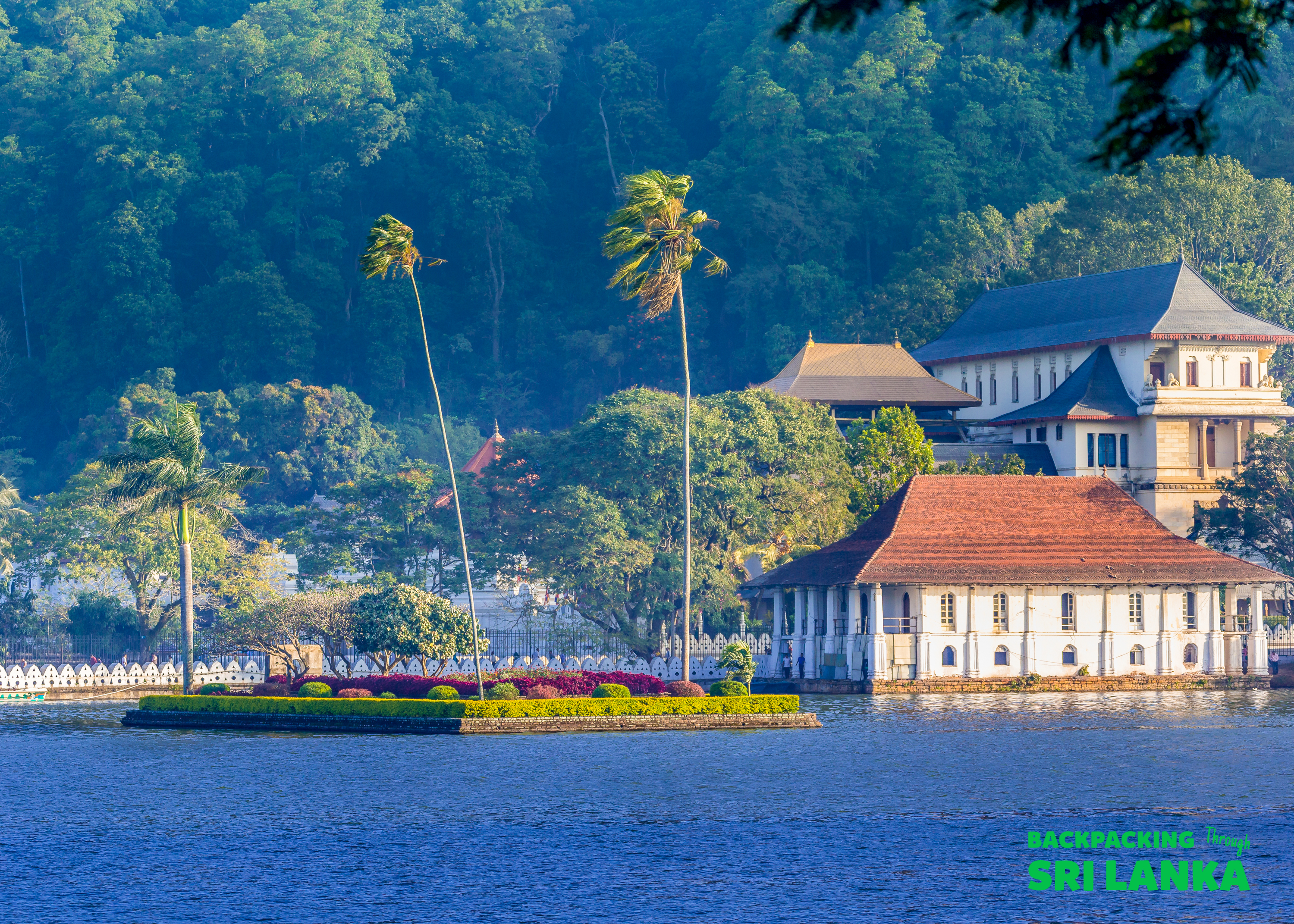 The sacred Temple of the Tooth and lush island on the serene Kandy Lake.