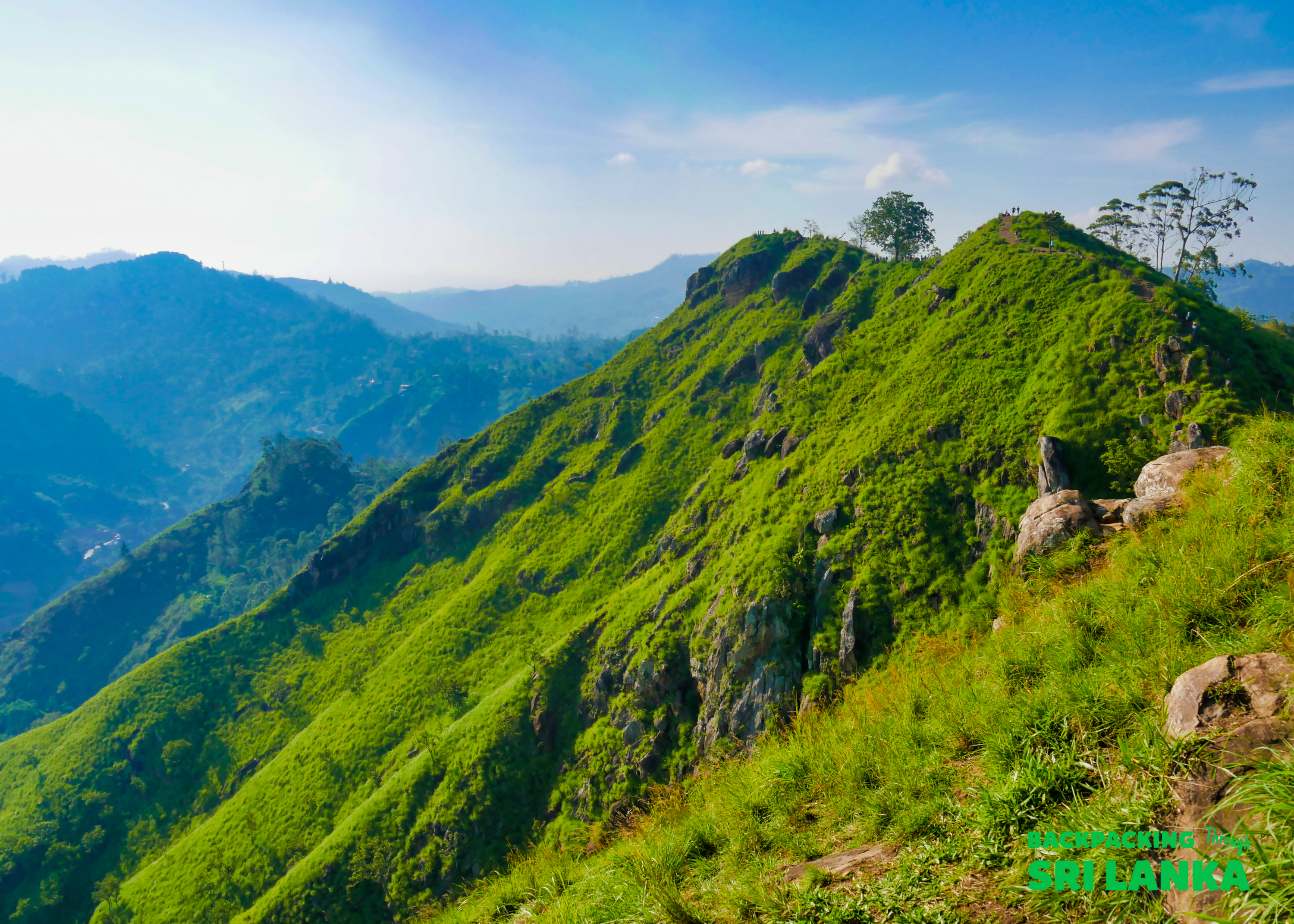 Dramatic views from a lush green mountain ridge at Little Adam's Peak in Ella, Sri Lanka.