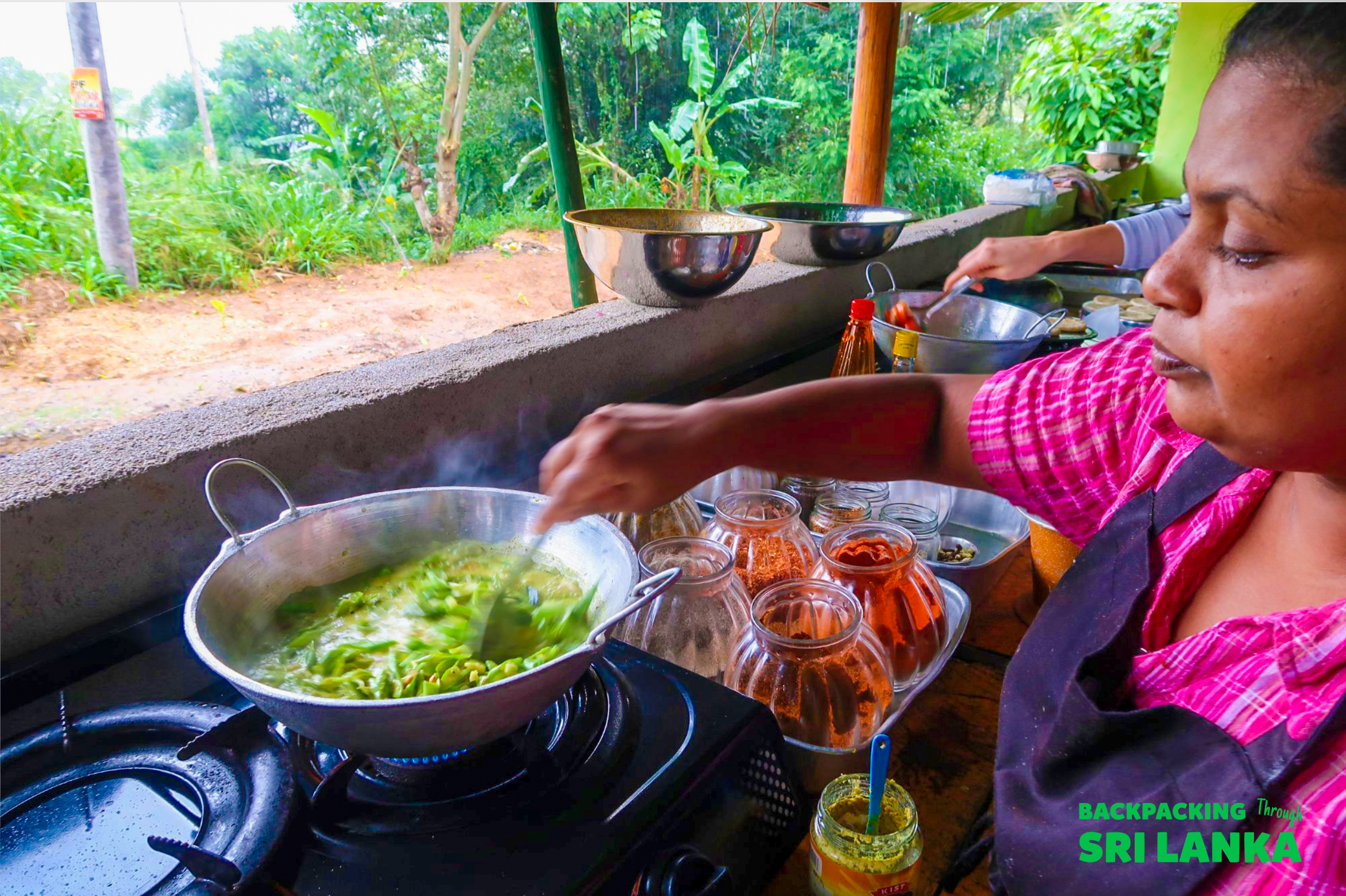 A local woman teaches a Sri Lankan cooking class, stirring a vibrant green curry in Ella.