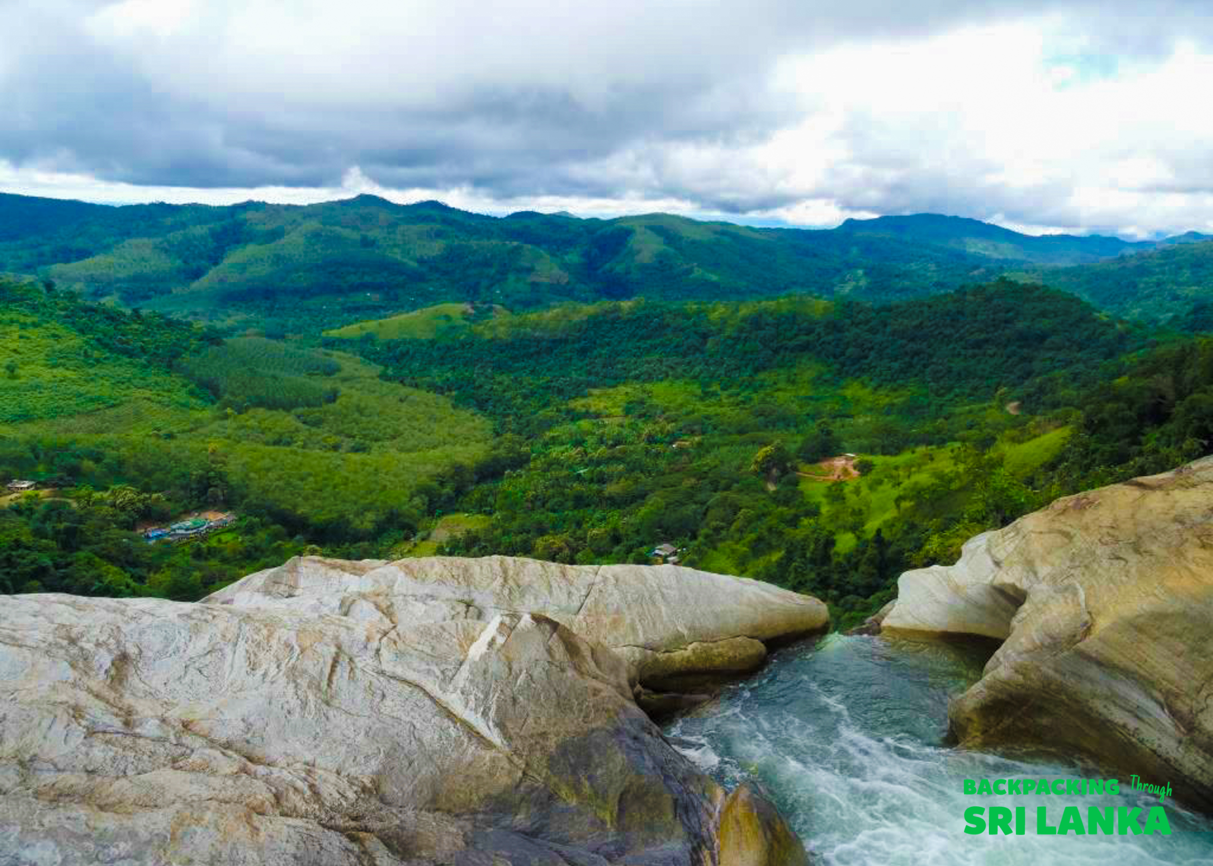 The breathtaking view from Diyaluma Falls, water cascading over rocks into a verdant valley below.