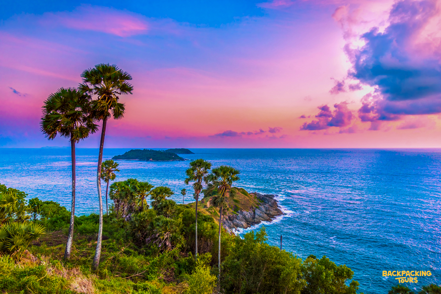 A breathtaking sunset paints the sky over Phuket's tropical coastline, dotted with palm trees and islands.