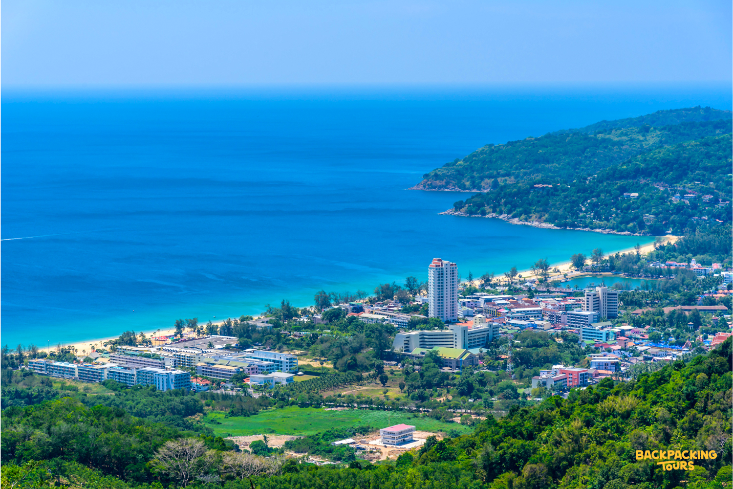 Stunning panoramic view of Phuket's vibrant coastline, featuring a long sandy beach and blue ocean.