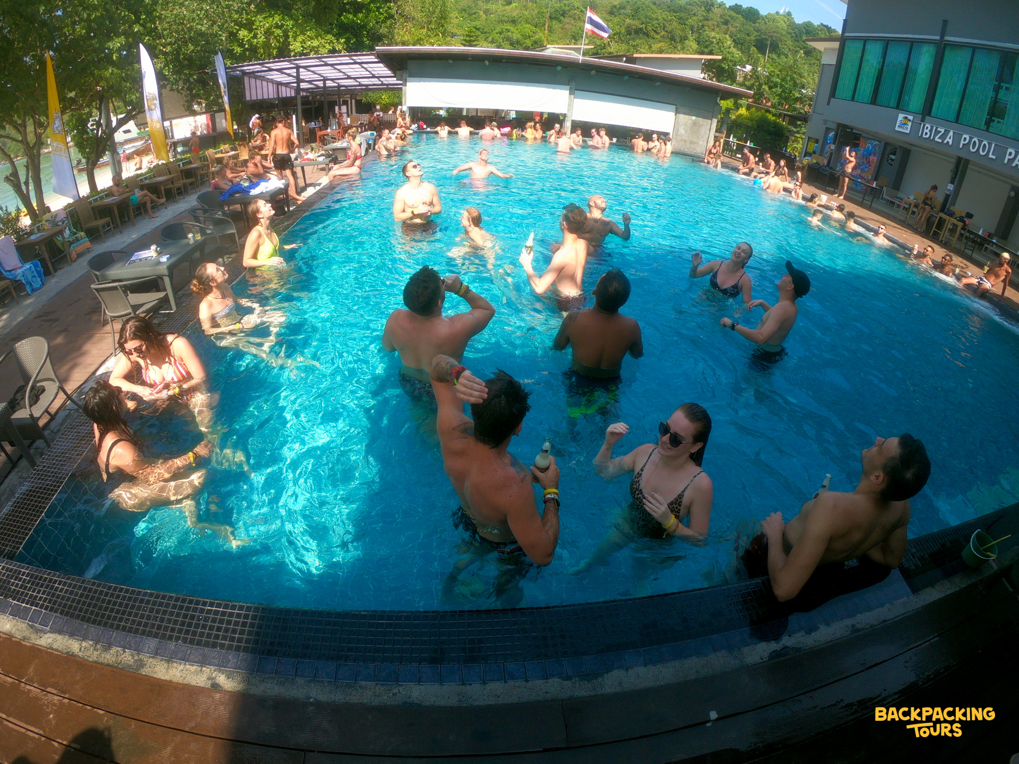 Travelers enjoy a lively pool party at a resort in Koh Phi Phi, Thailand.