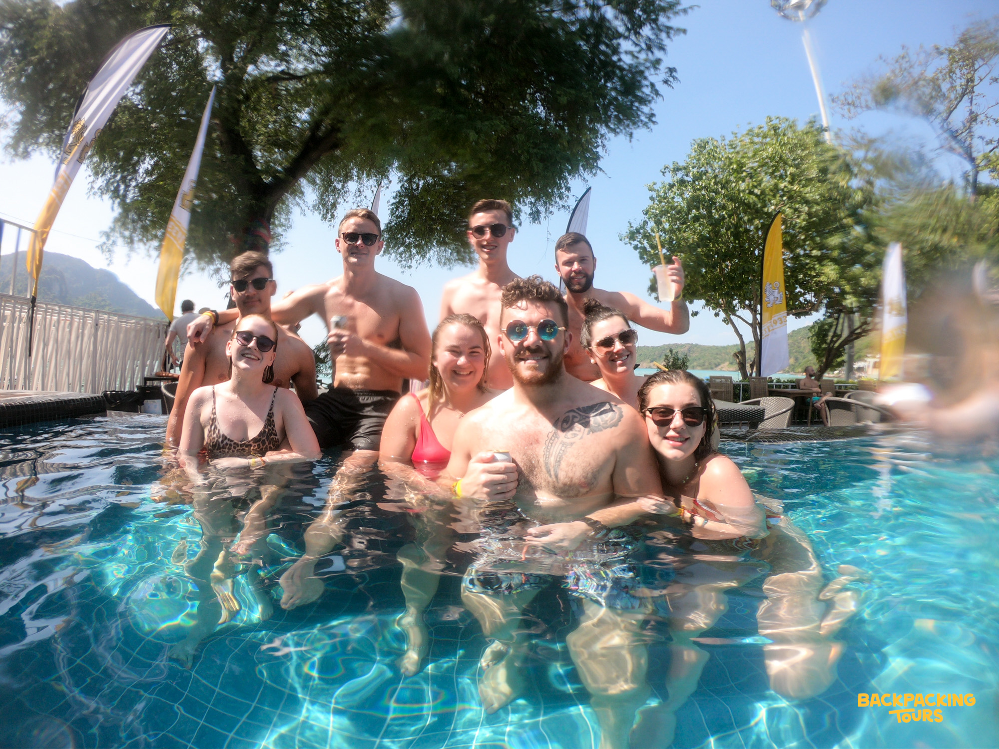 A happy group of backpackers enjoying a sunny day together in a swimming pool on Koh Phi Phi.