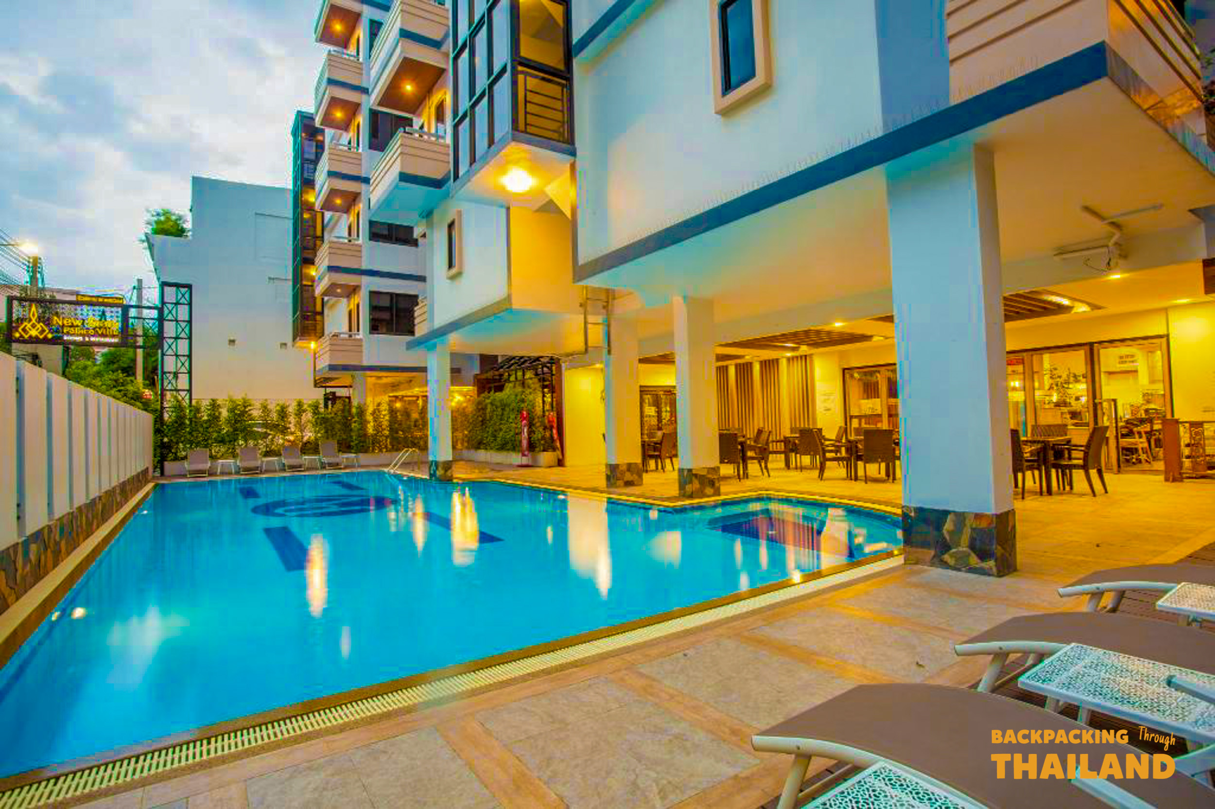 The inviting swimming pool and modern architecture of a comfortable hotel in Bangkok at dusk.