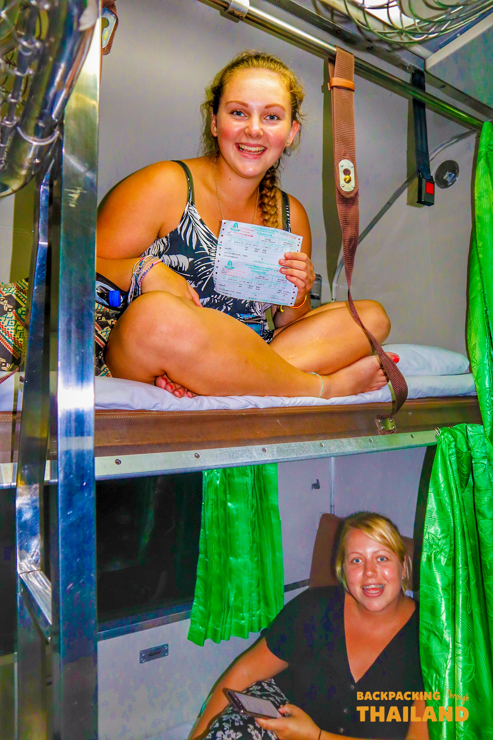 Travelers resting in bunk beds on overnight train to Surat Thani.