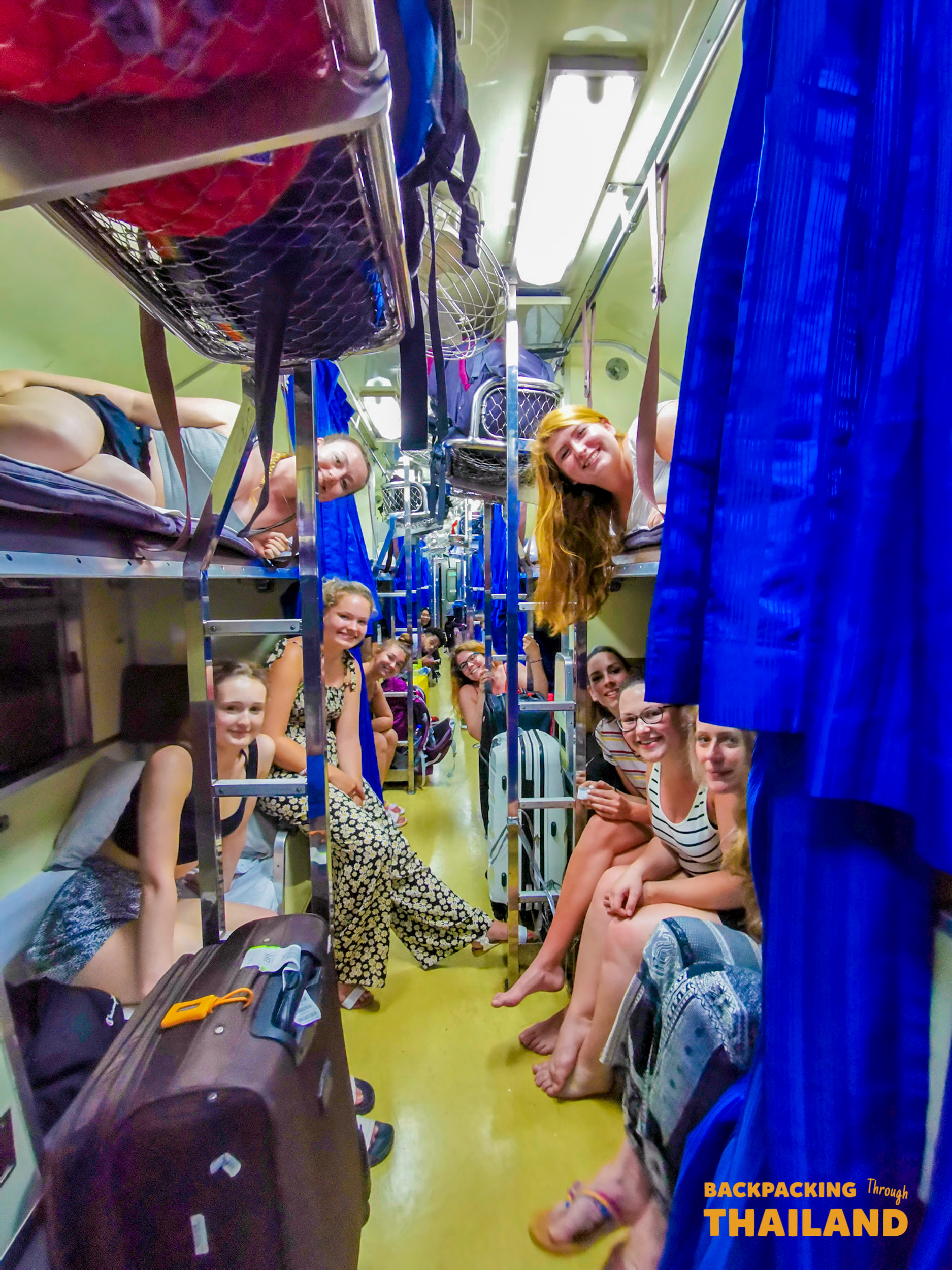 Group of travelers enjoying night train journey in Thailand.