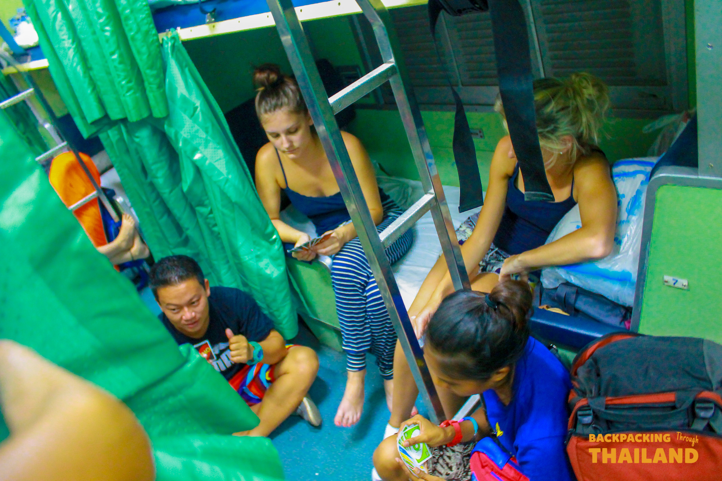 Backpacking group sitting together on Thailand overnight train.