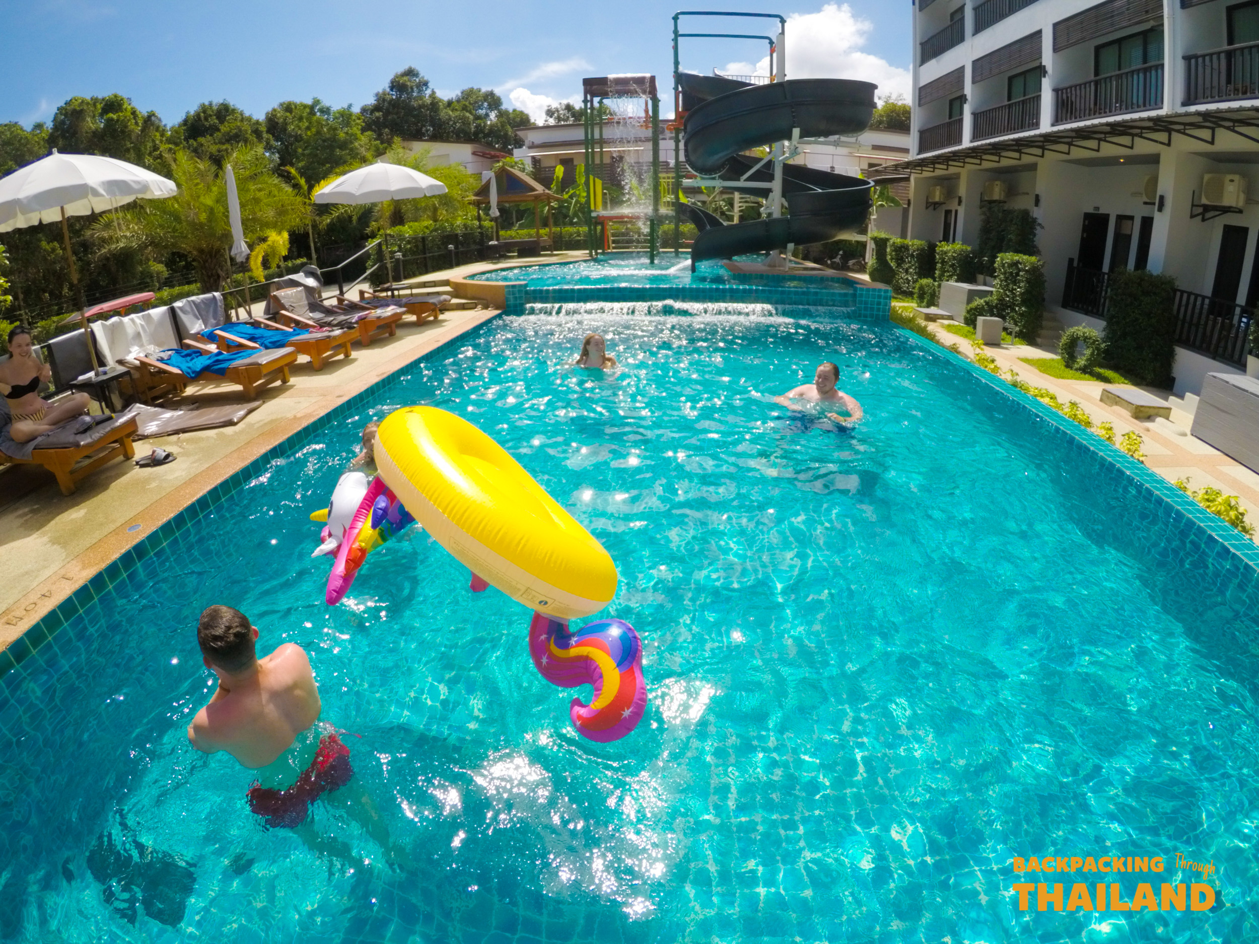 Travelers relaxing together at Krabi accommodation pool.