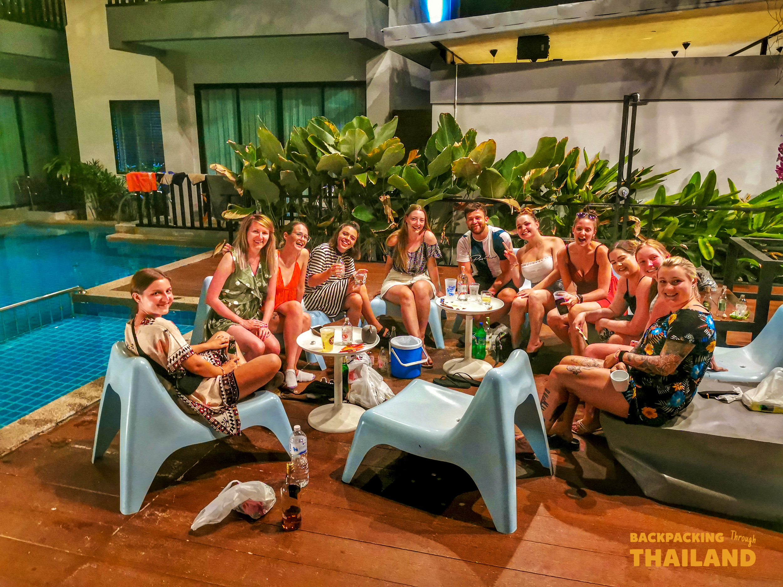 Travelers socializing poolside at Krabi accommodation.