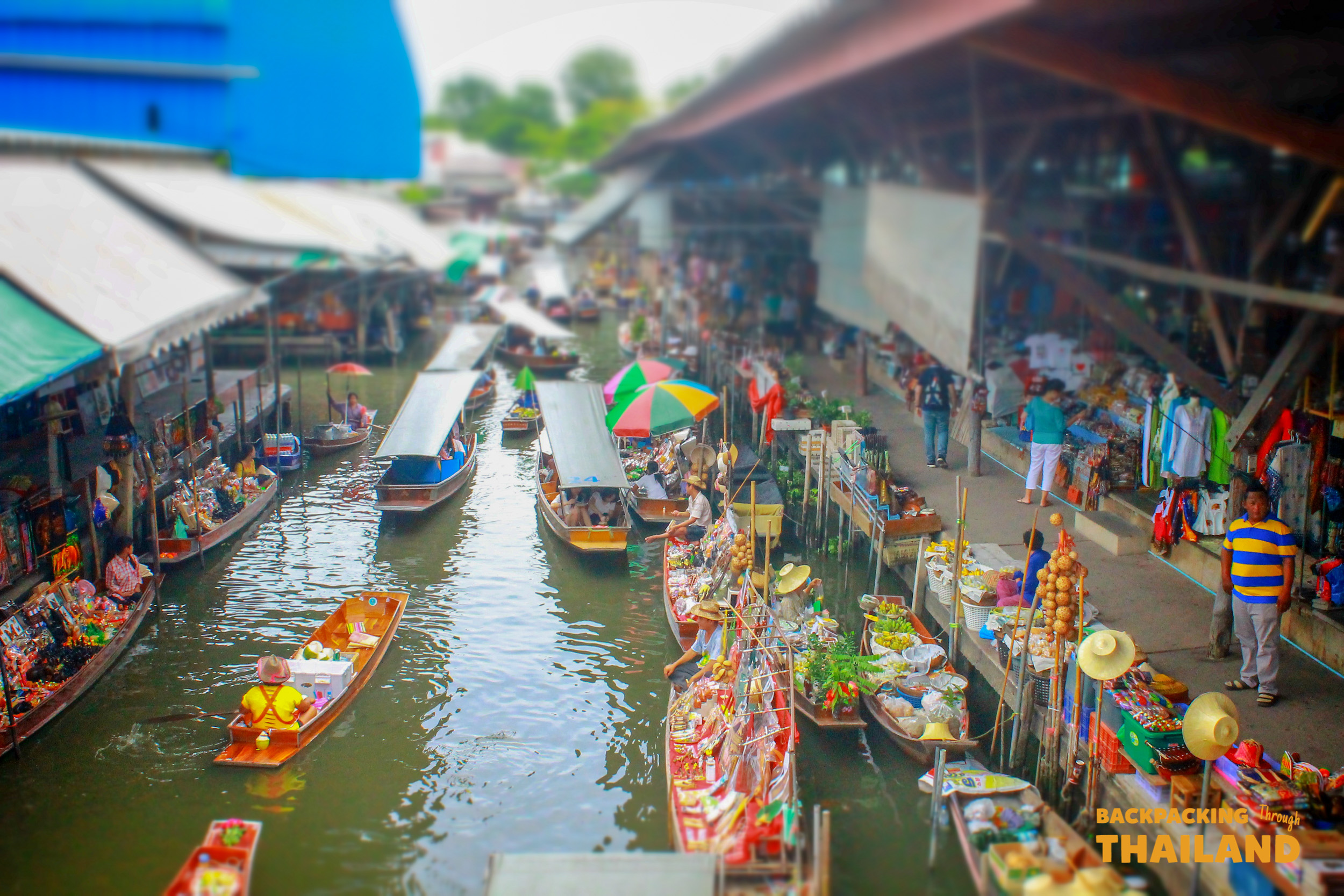 Boats filled with fresh produce and goods at the lively Amphawa Floating Market in Thailand.