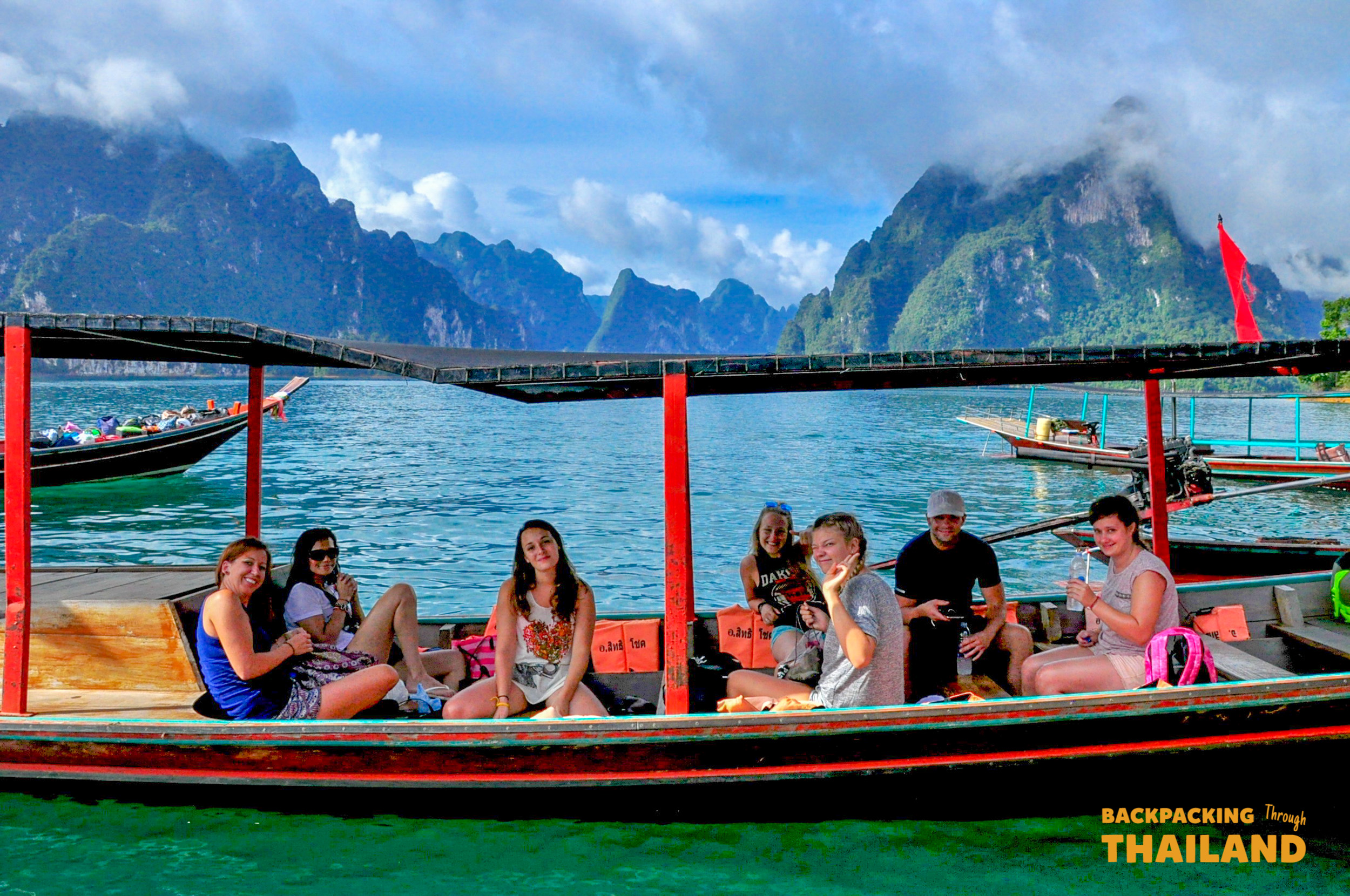 Backpacking friends enjoying scenic boat ride in Khao Sok.
