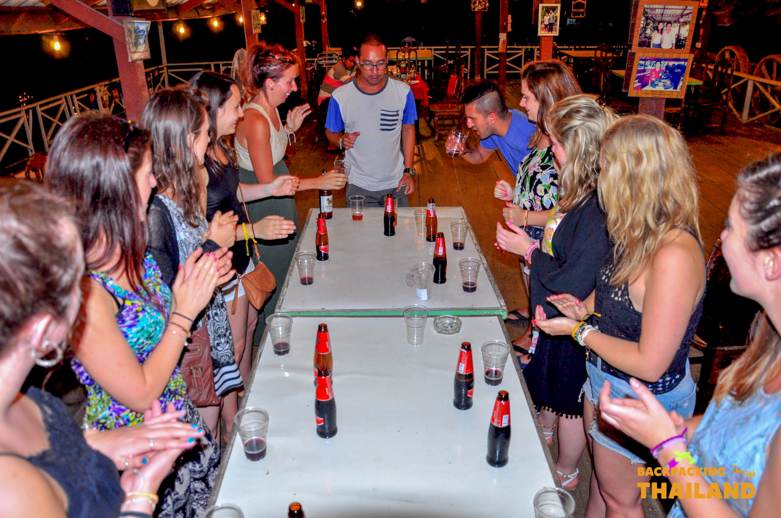 Backpacking group playing games at night on raft house.