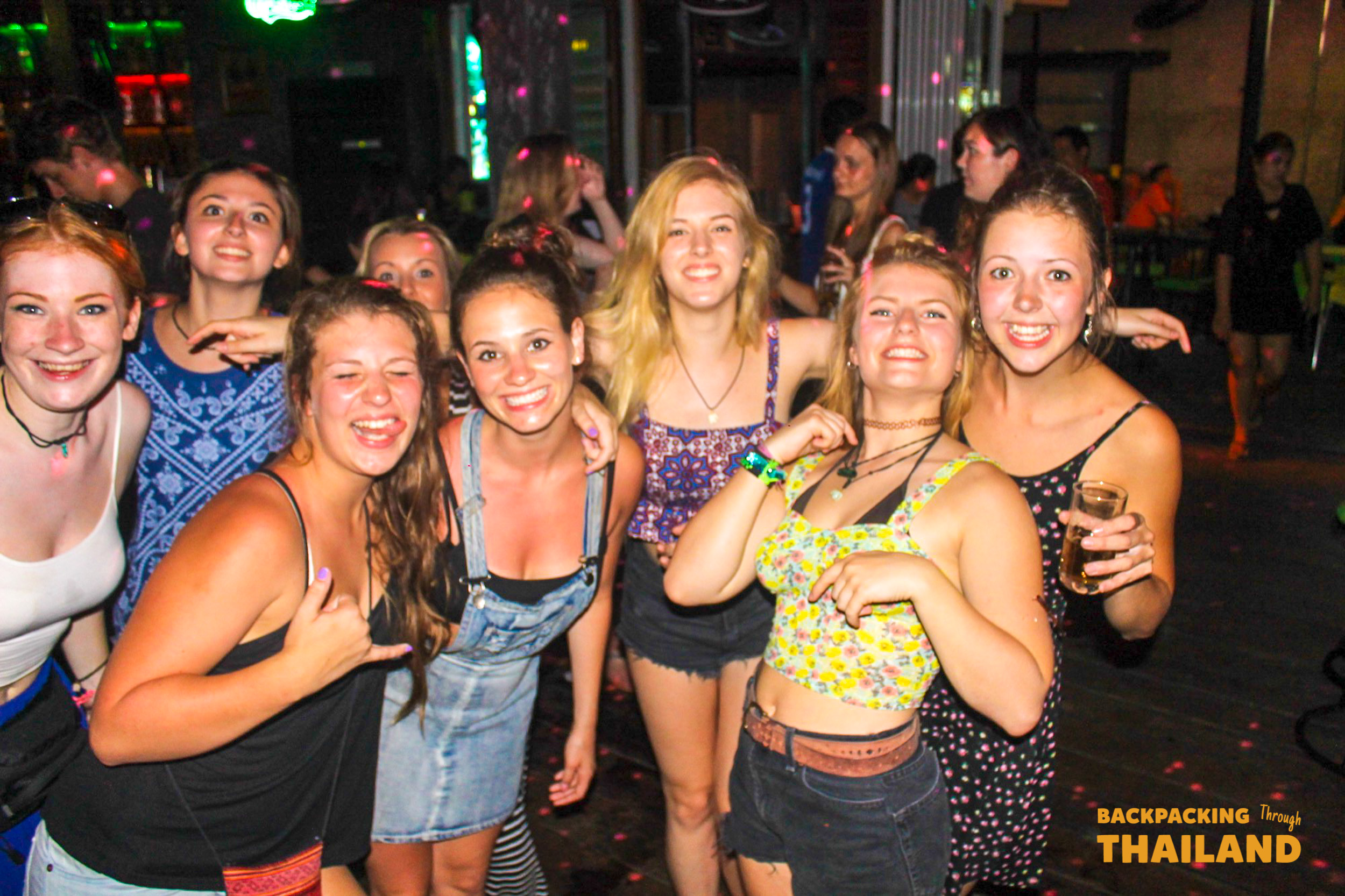 Friends posing for night out in Krabi bar.