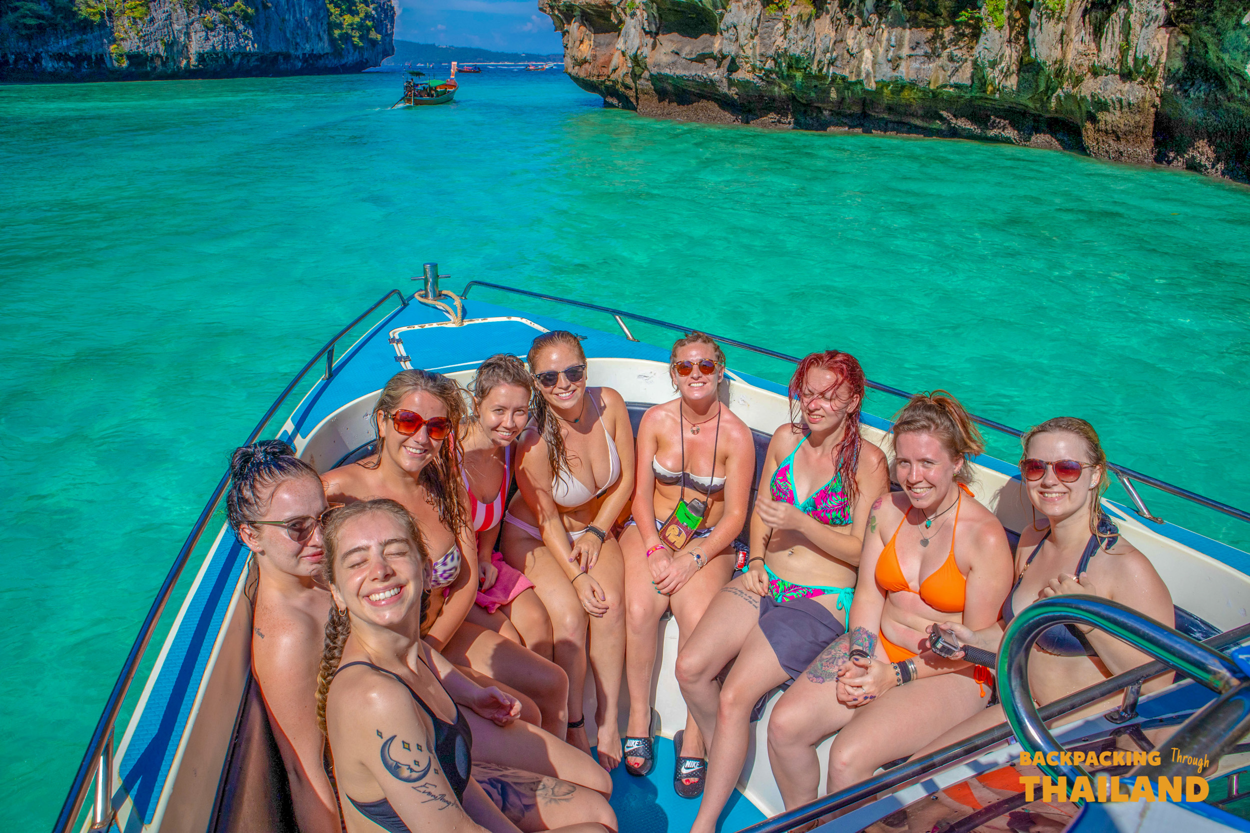 Smiling women on a speed boat enjoying the turquoise waters and limestone cliffs of Koh Phi Phi.