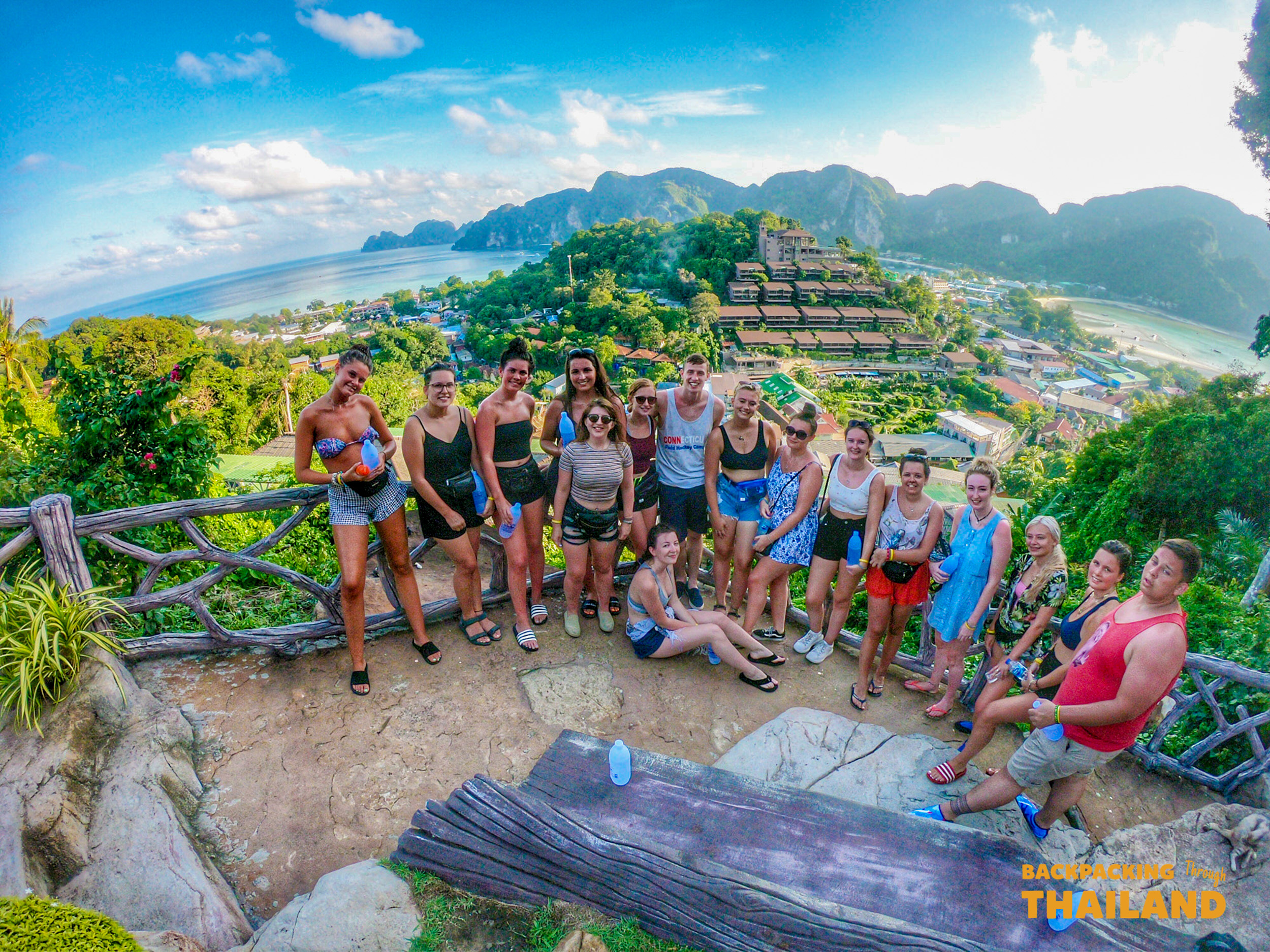 Happy backpackers pose at the stunning Koh Phi Phi viewpoint overlooking the bay.
