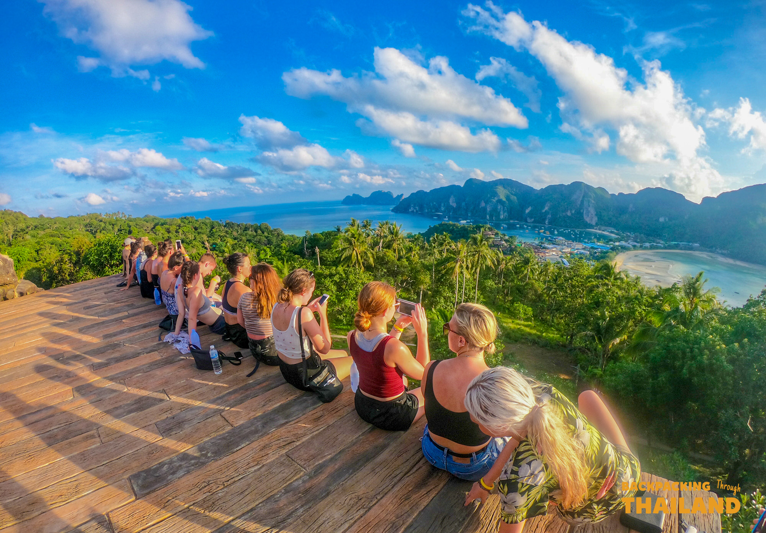 A group of backpackers capture the stunning panoramic view of Koh Phi Phi's twin bays.