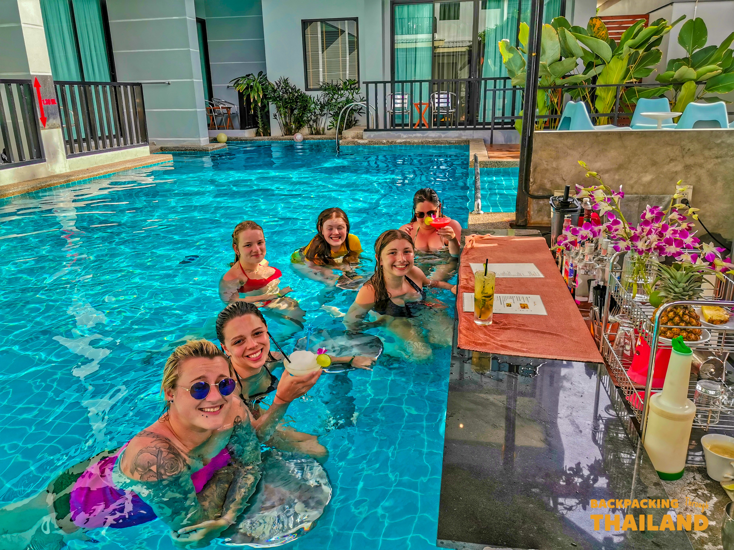 Six friends enjoying a fun and relaxing day by the pool with drinks in Krabi.
