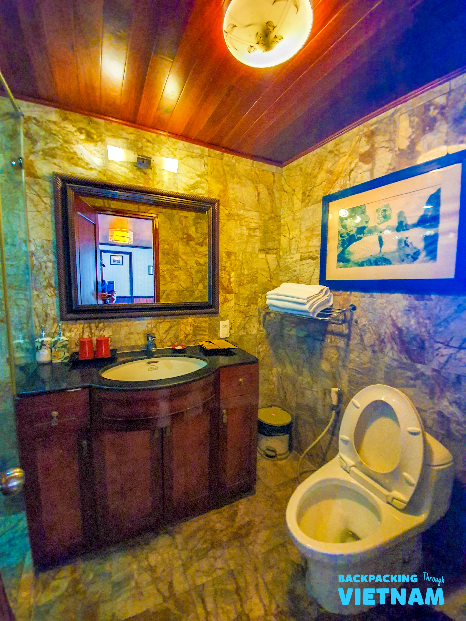 The elegant private bathroom on your Halong Bay sleeper boat, with marble and wood finishes.