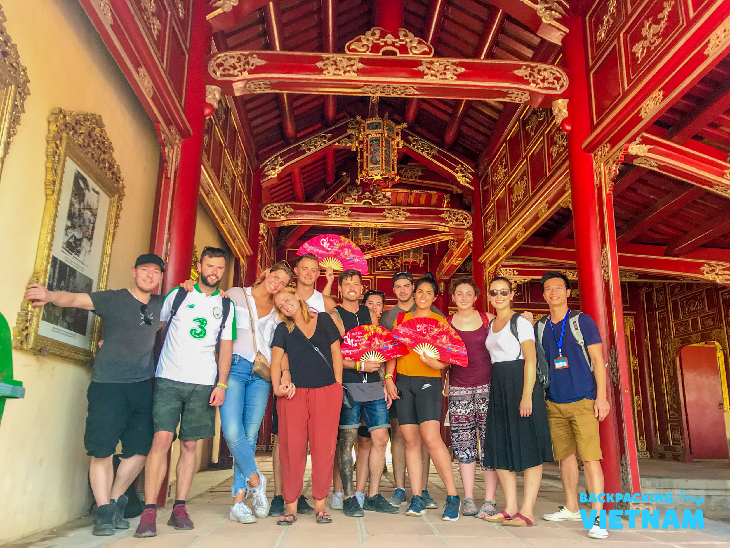 A group of happy backpackers posing inside the ornate Imperial City in Hue, Vietnam.