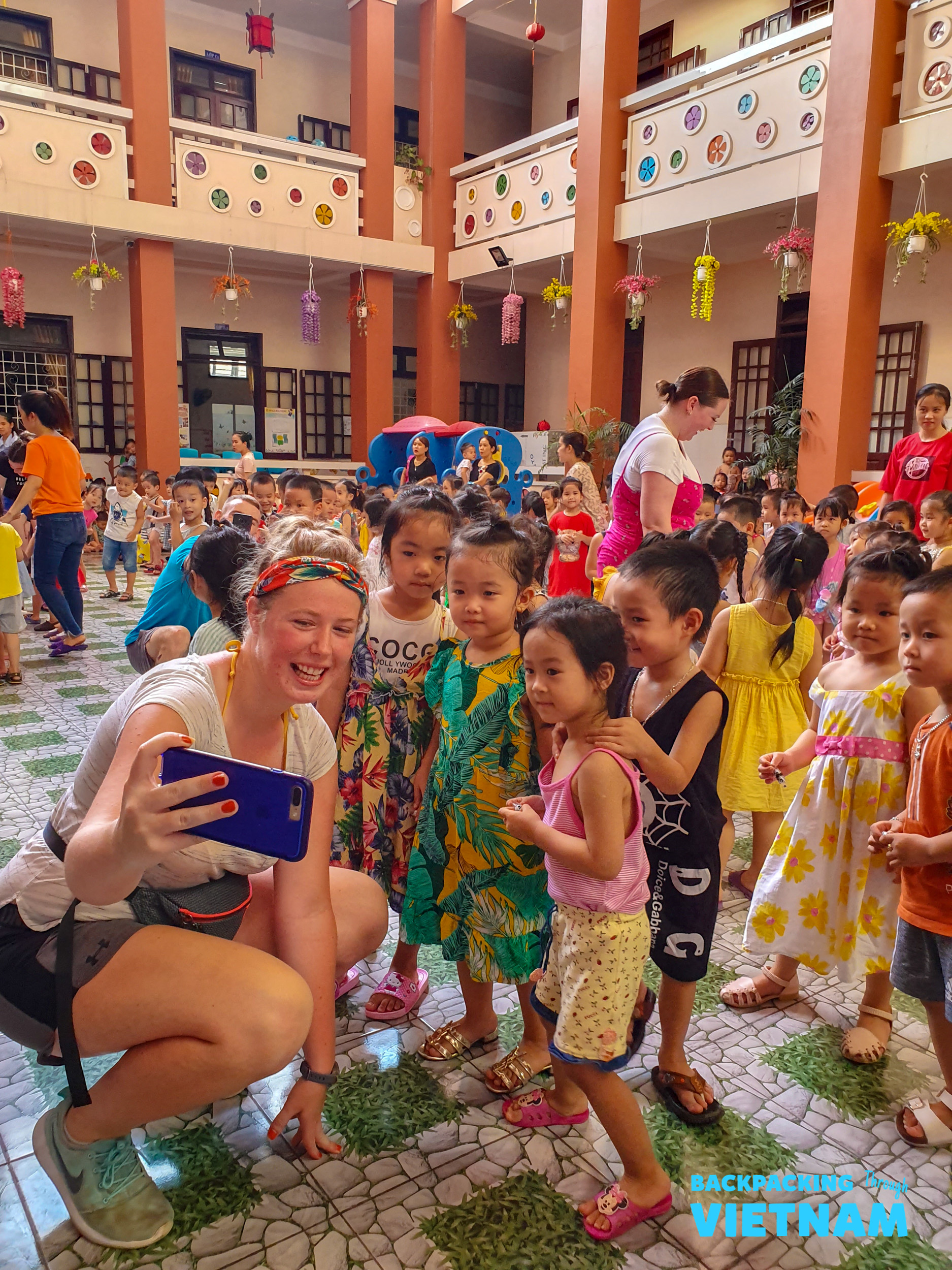 Backpacking traveller taking selfie with local children