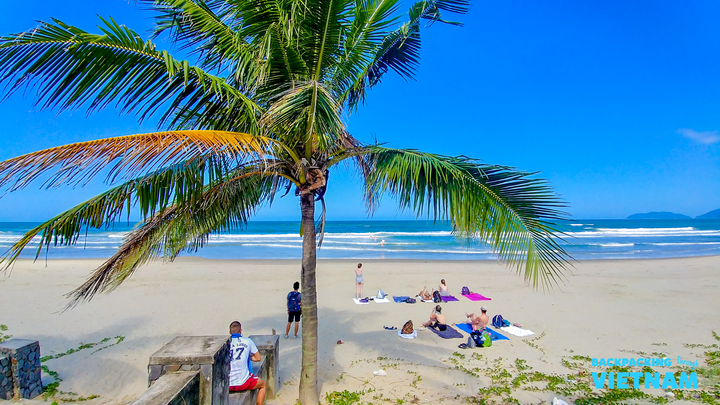 Relaxing on a beautiful sandy beach in Hoi An, Vietnam, with palm trees and ocean waves.