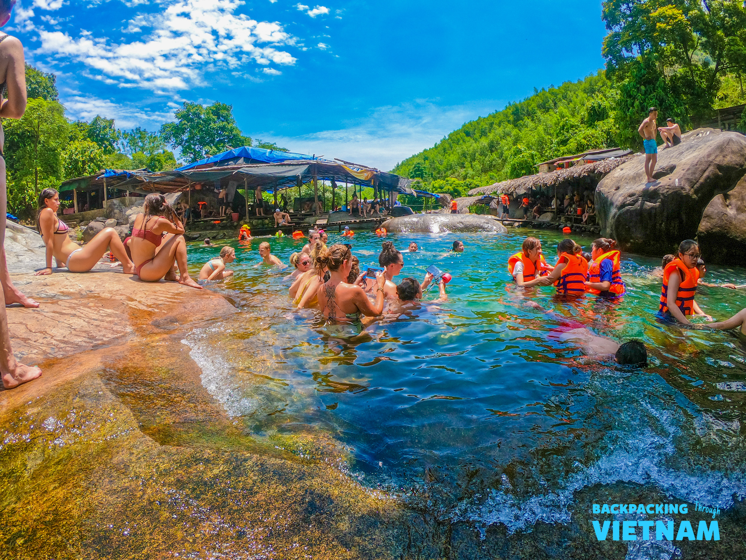 Backpacking group swimming in natural spring at Hai Van Pass
