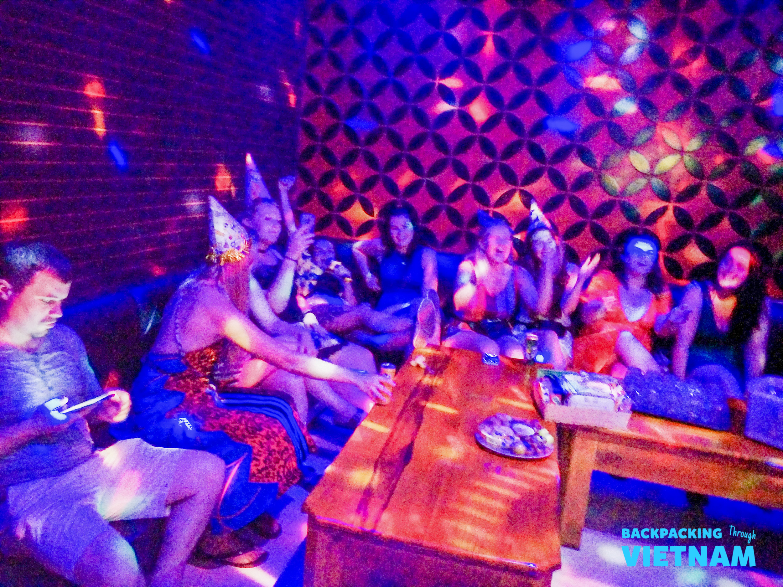 Friends bond and party under vibrant disco lights during a fun night out in Hoi An.