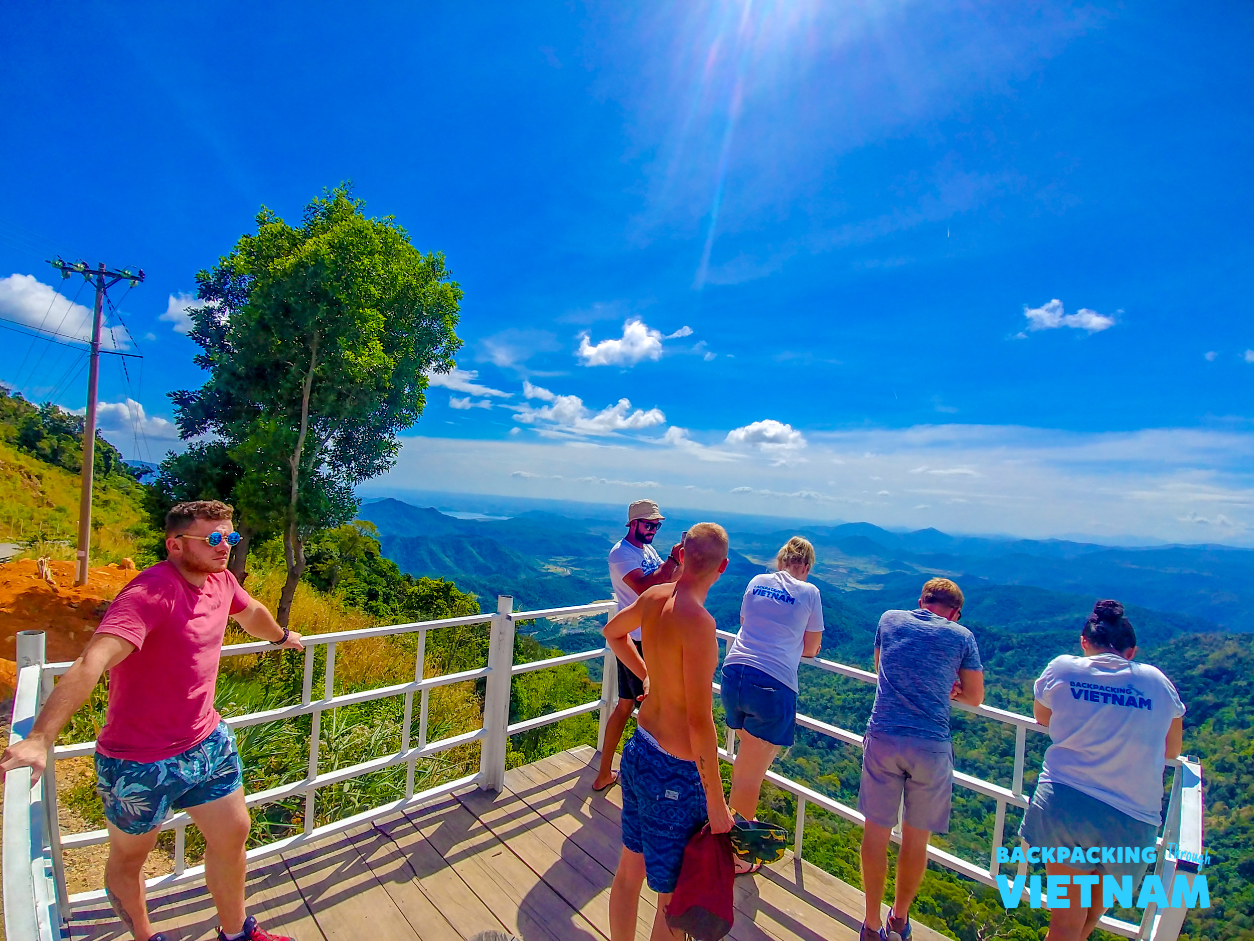 Backpacking group posing on wooden bridge in Dalat