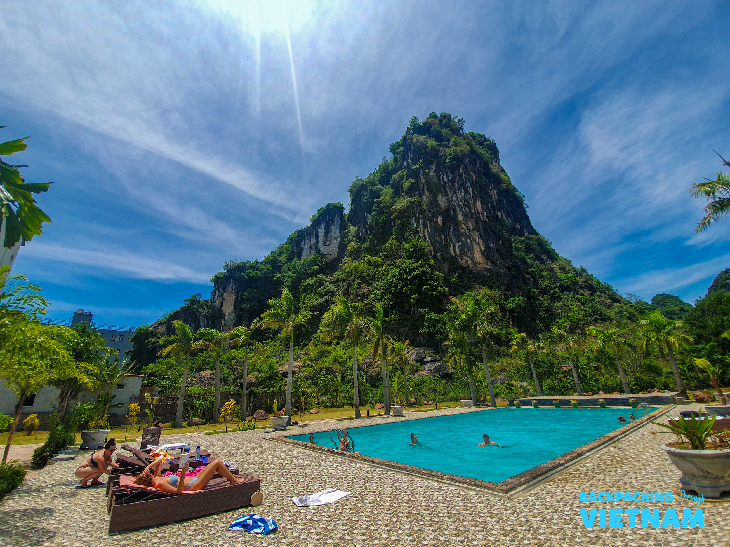Relaxing by the pool with majestic karst mountains towering above in Phong Nha, Vietnam.