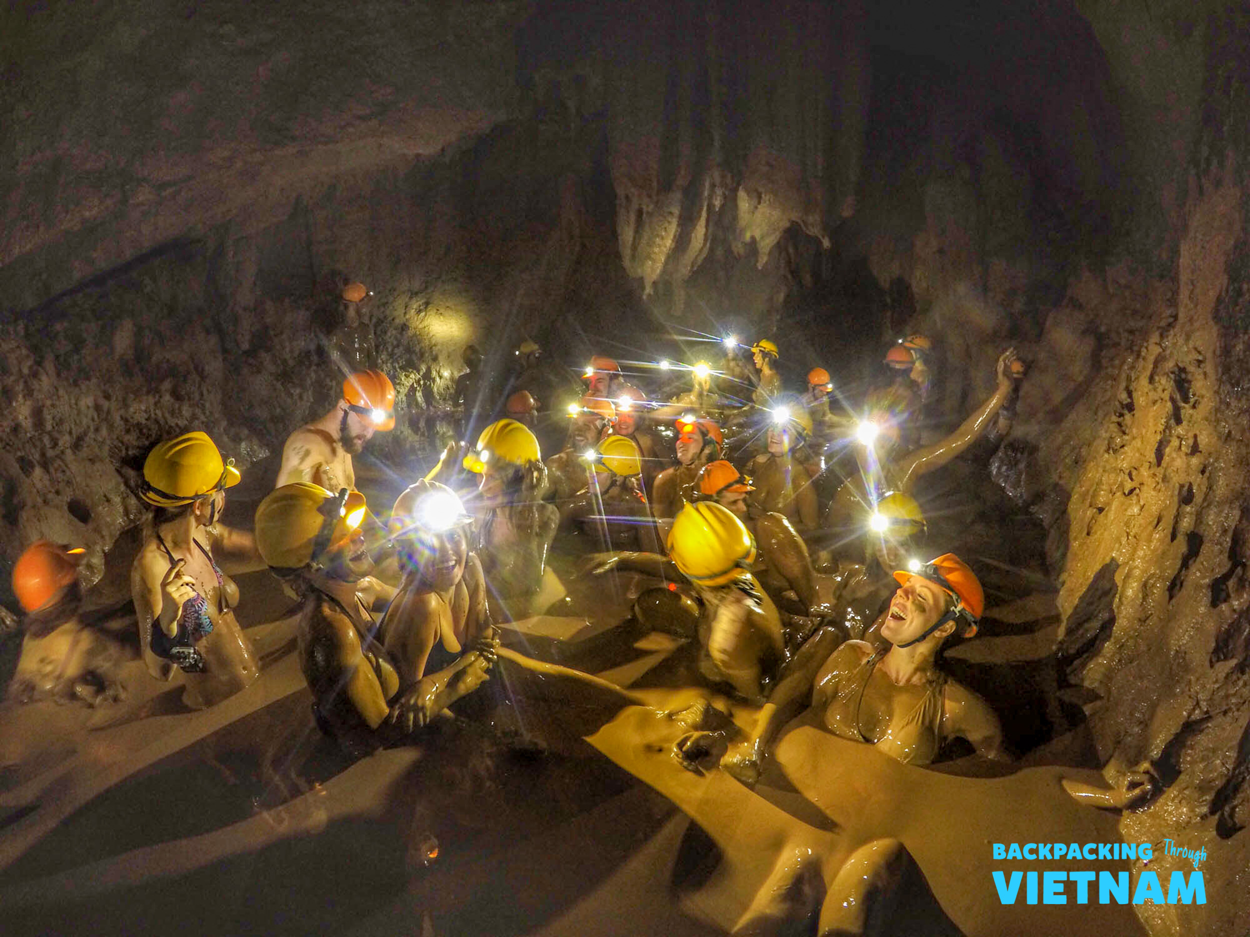 Backpacking group covered in mud inside Dark Cave