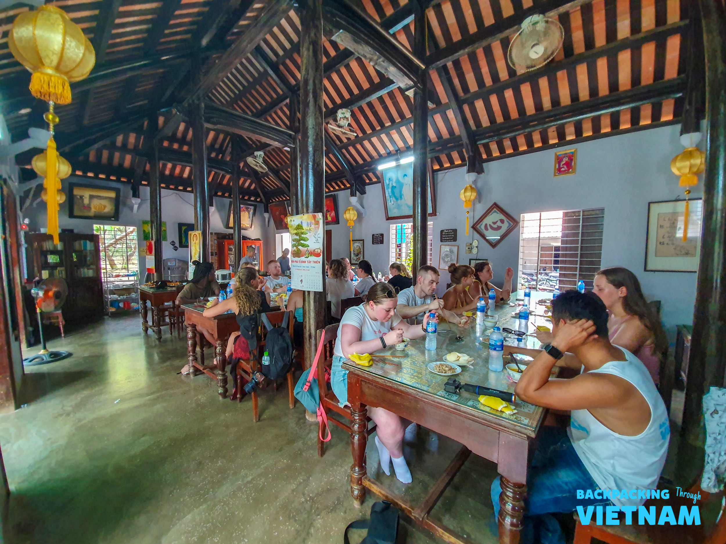 Young backpackers share a relaxed meal in a charming, traditional restaurant in Hue, Vietnam.