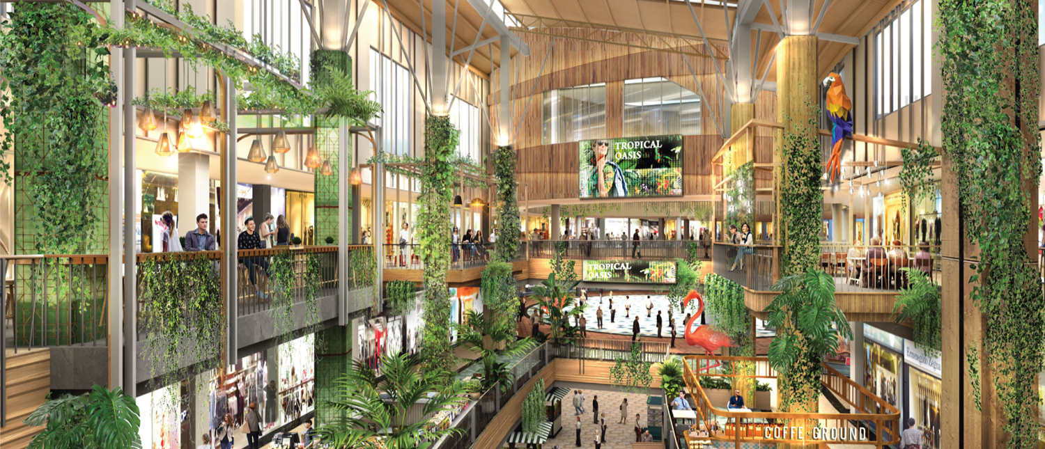 Lively multi-story shopping mall in Phuket with abundant green plants, wooden accents, and many shoppers.