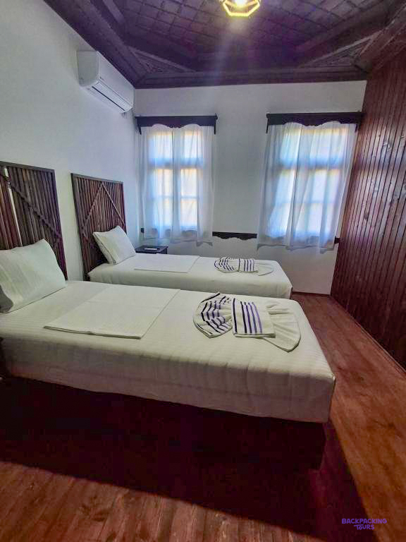 A room with a double and a single bed at the guesthouse in Gjirokastër