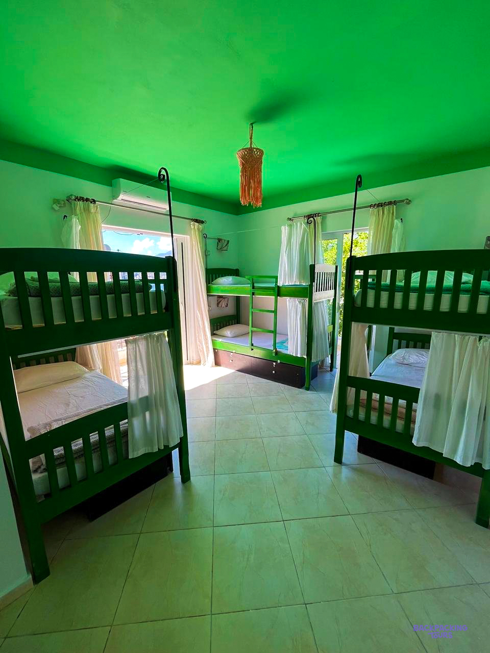 A dorm room with green bunk beds at the hostel in Himarë